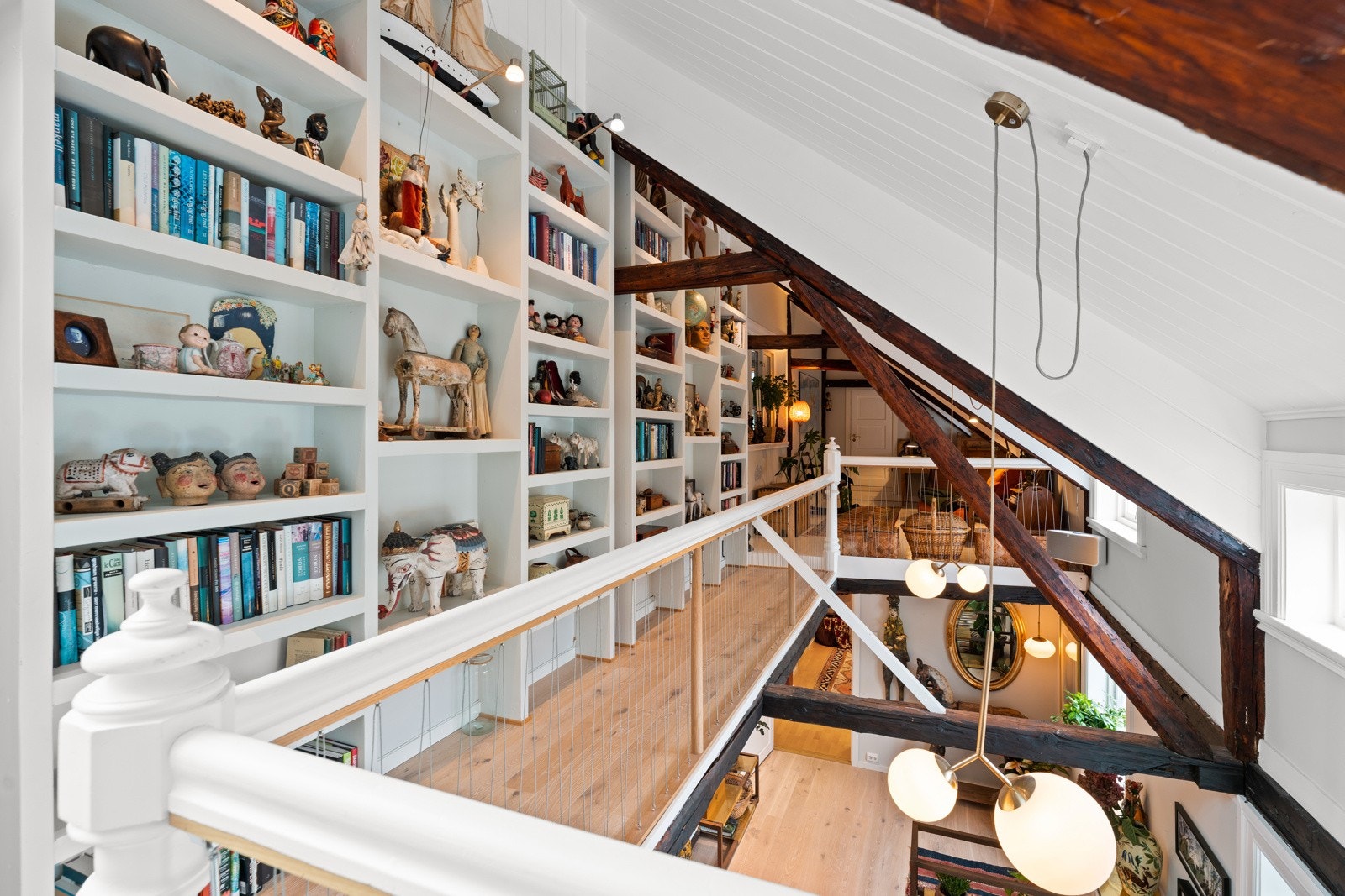 Loftet har en fin sjarme, med skråtak og synlige trebjelker. Plassbygde hyller som strekker seg helt opp i taket gir god utnyttelse av arealet. Galleribilde