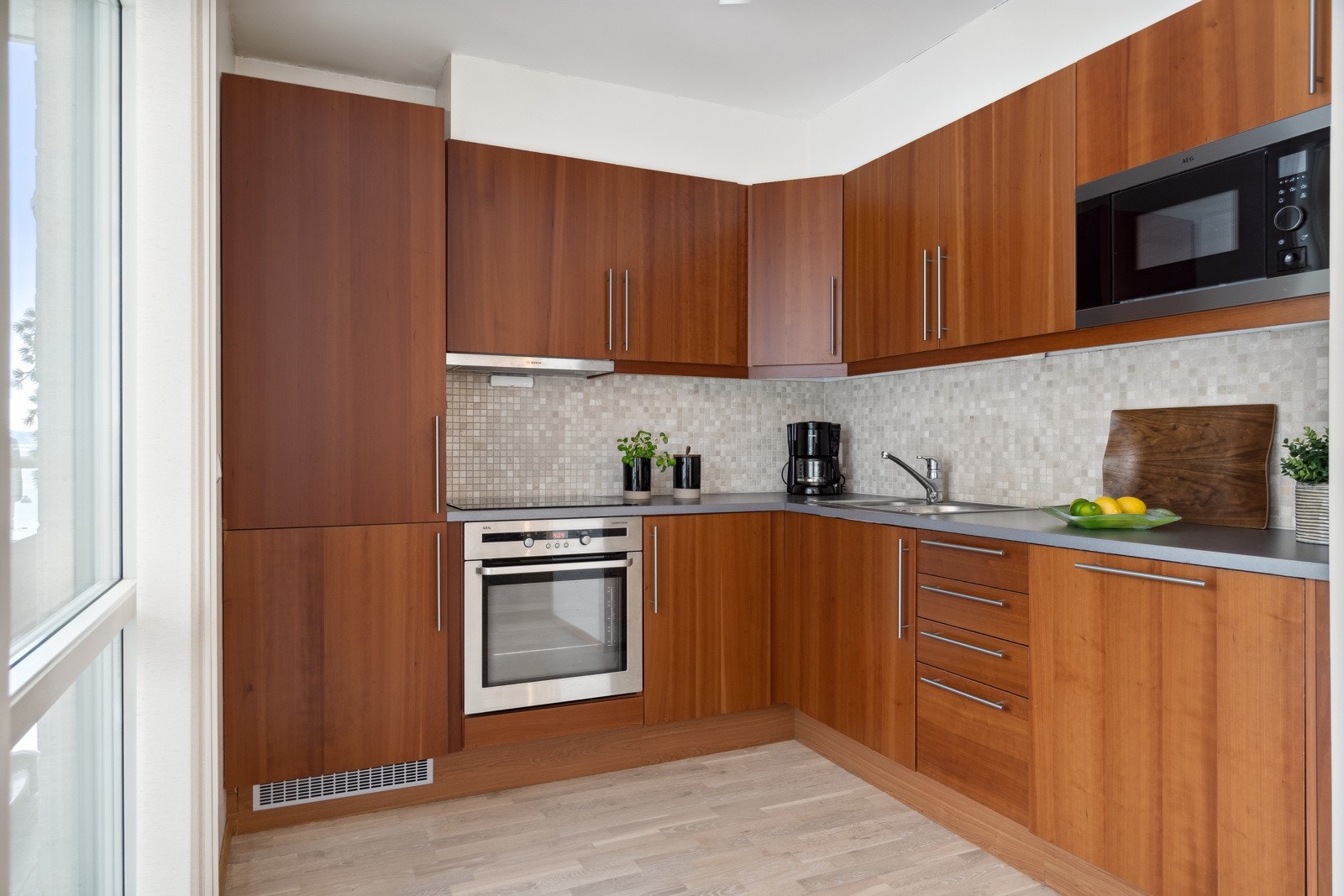 Pent hjørnekjøkken med mye skap- og benkeplass Galleribilde