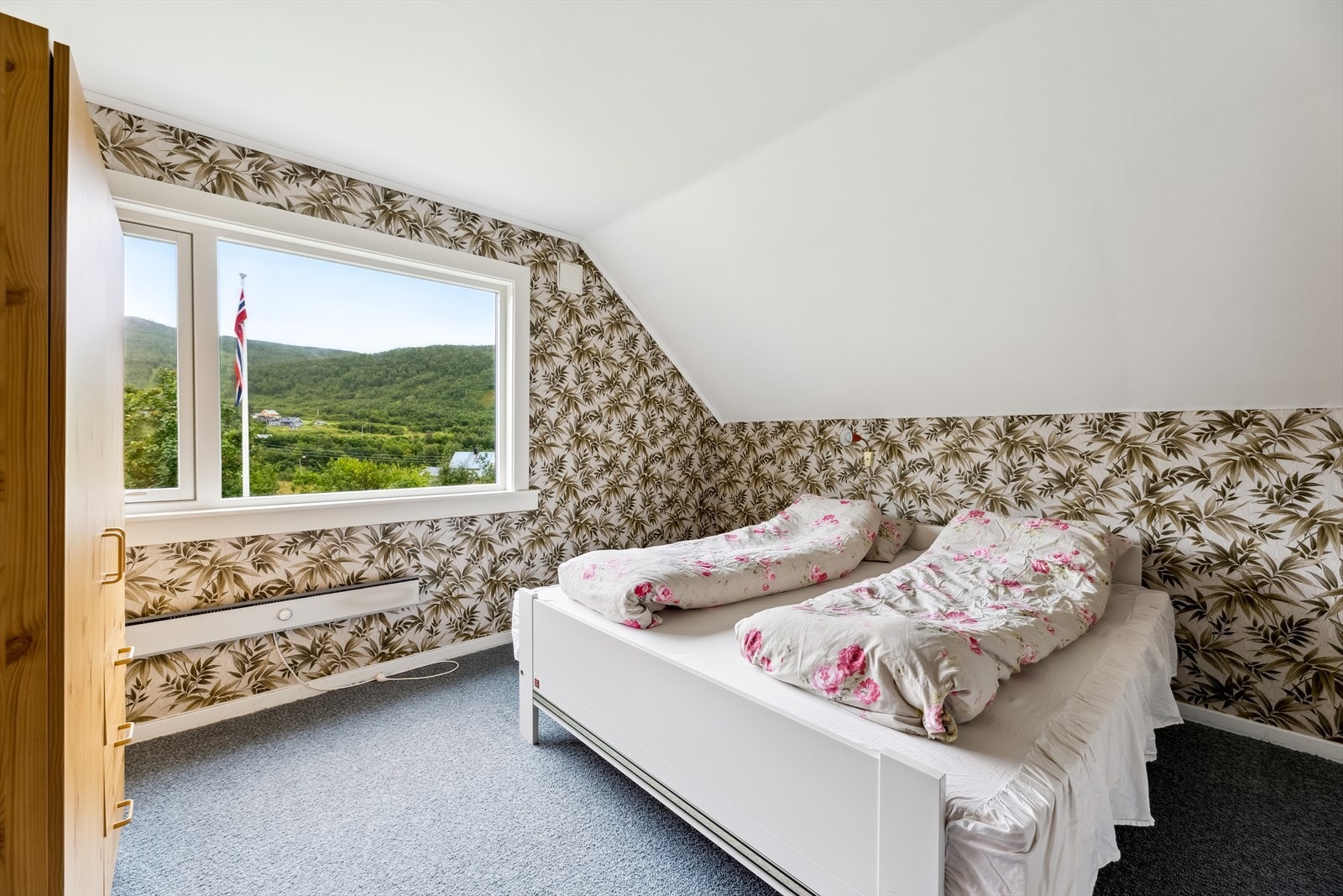 Øvrige soverom ligger i loftsetasjen og har tapet med blad- og blomstermønster. Galleribilde