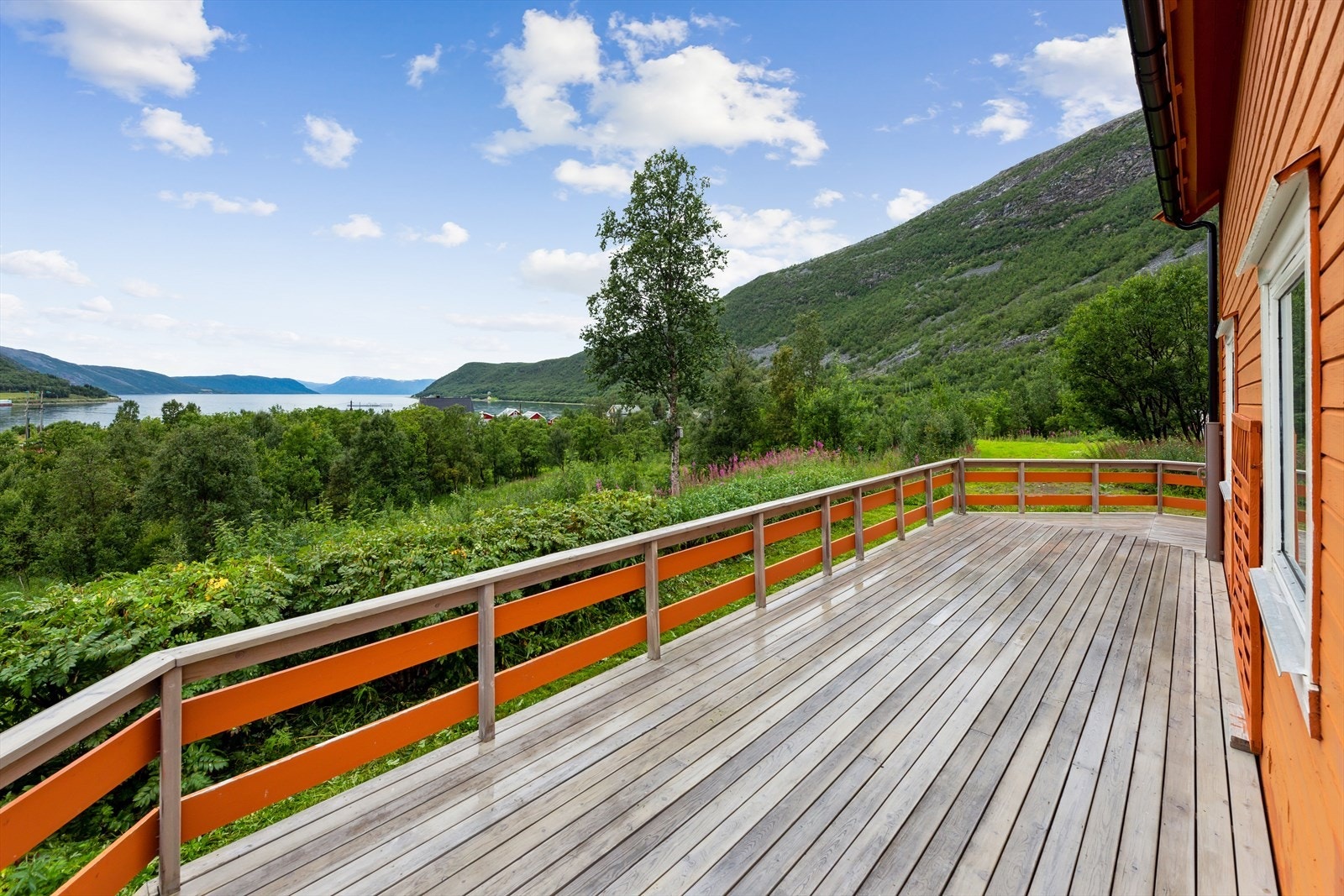 Stor terrasse med flott utsikt mot fjord og fjell. Galleribilde