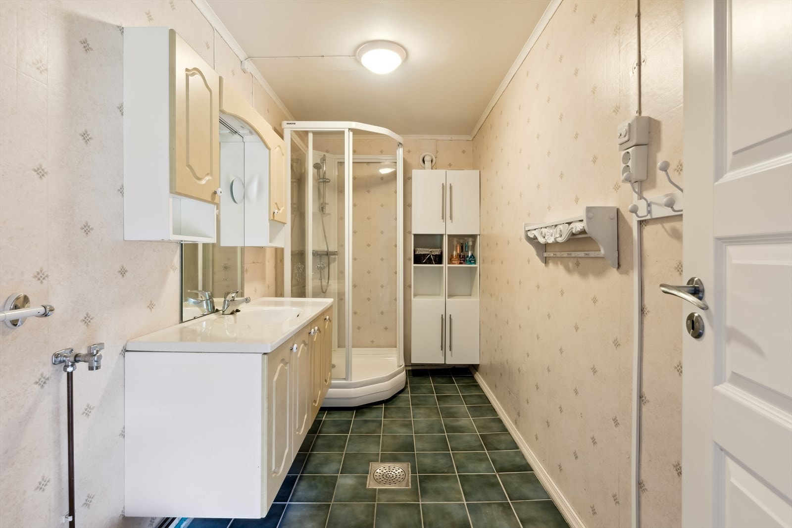 Baderom med tapet på vegg og fliser på gulv med gulvvarme. Galleribilde