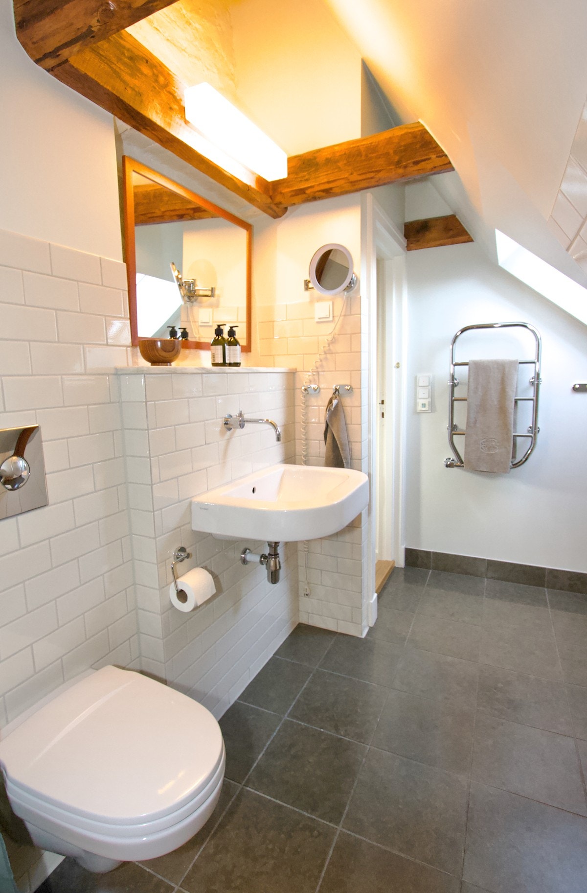 Badet er utstyrt med vegghengt wc, servant, dusj i innmurt badekar. Galleribilde