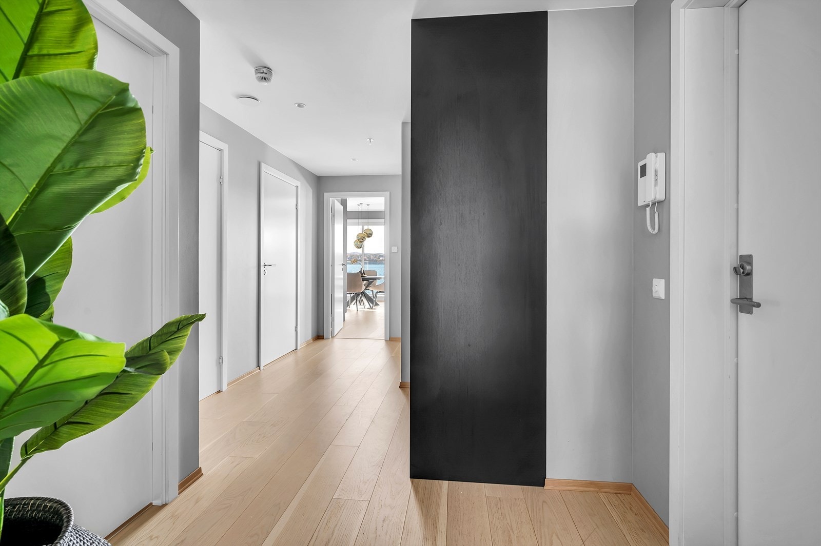 Gangen har sort moderne skyvedørsgarderobe og plass til oppheng av yttertøy og sko Galleribilde