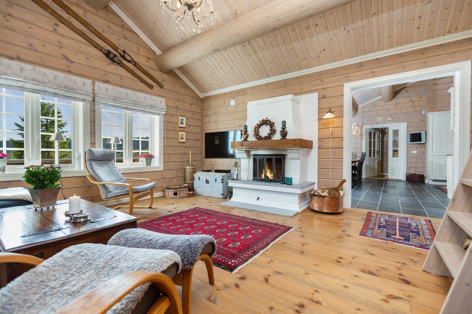 Stua har pent behandlet panel og et flott tregulv som gir et lunt uttrykk Galleribilde