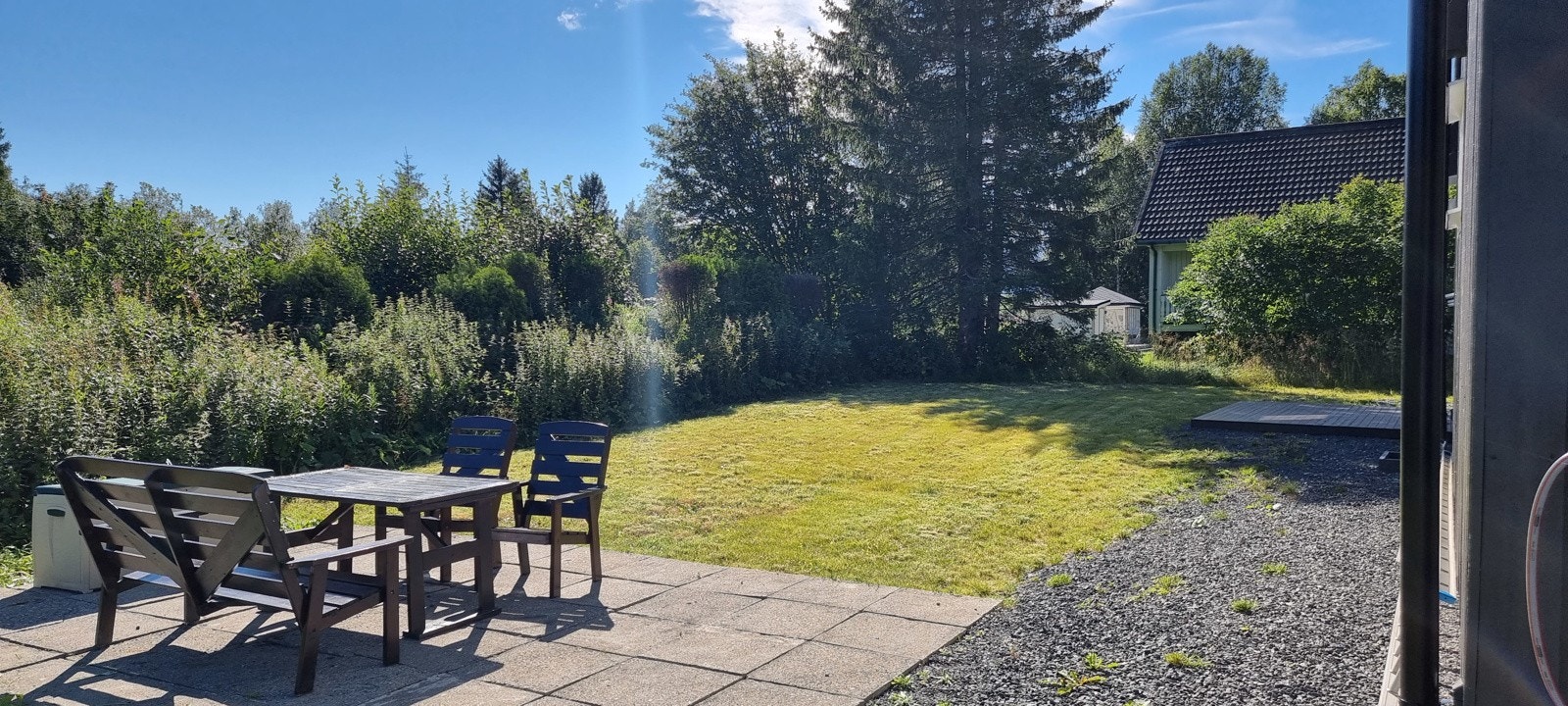 Solrik tomt hvor deler er opparbeidet med plen. Galleribilde