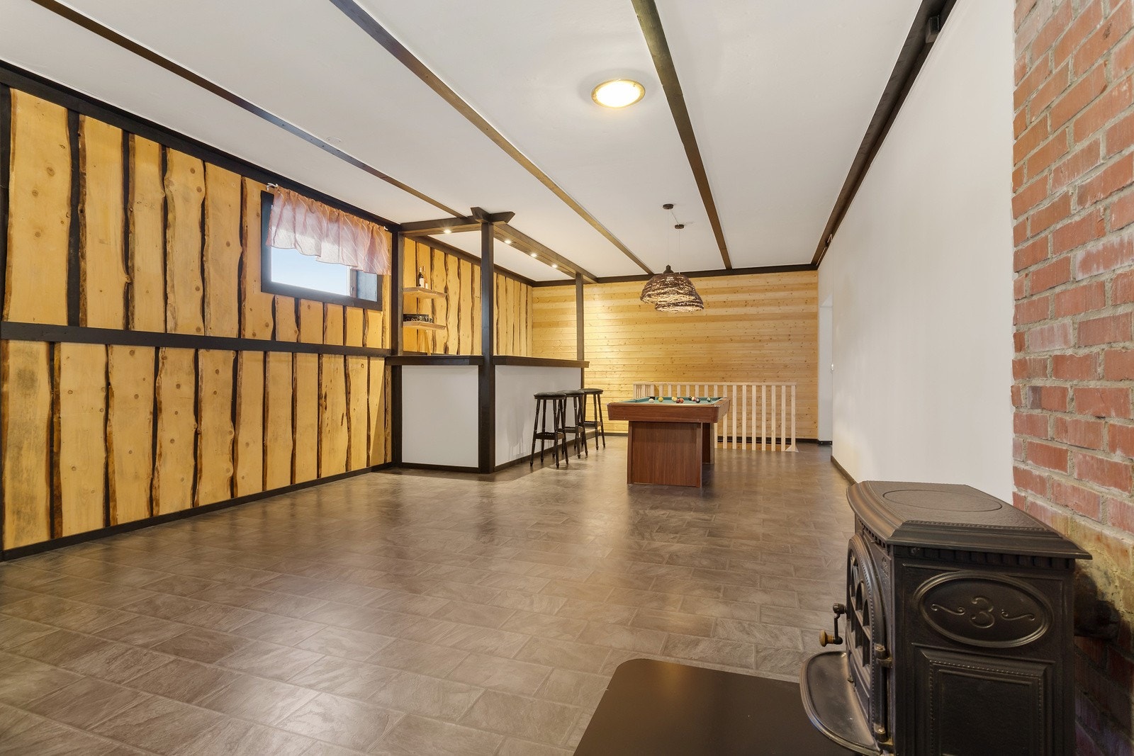 Stilig innredet bar i 1. etg. fra 2022, merk deg villmarkspanelet langs den ene veggen. Fra baren har du trapp ned til kjelleretasjen. Baren er tilknyttet hoveddelen av huset og herfra er adkomst via trapp opp til 2. etg. Galleribilde