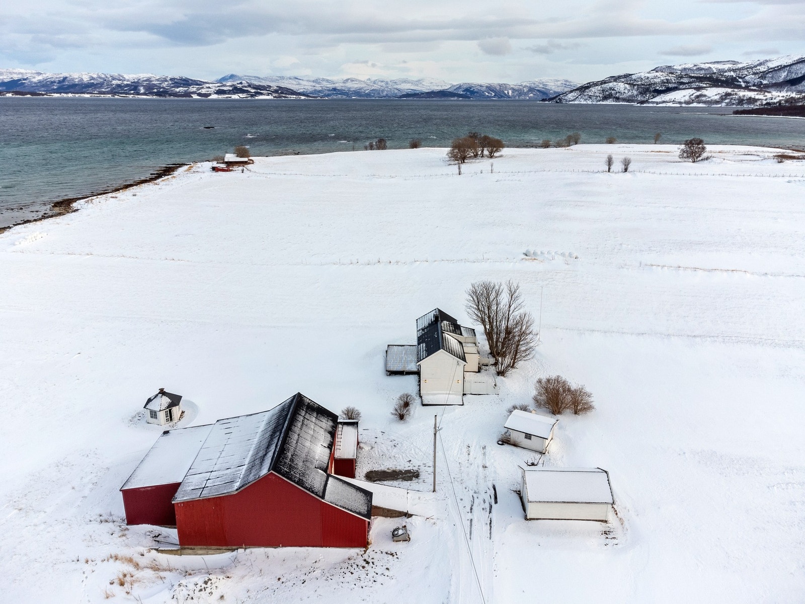 Oversiktsbilde - eiendommen er innholdsrik og inneholder fjøs, anneks, naust og grillhytte. Galleribilde