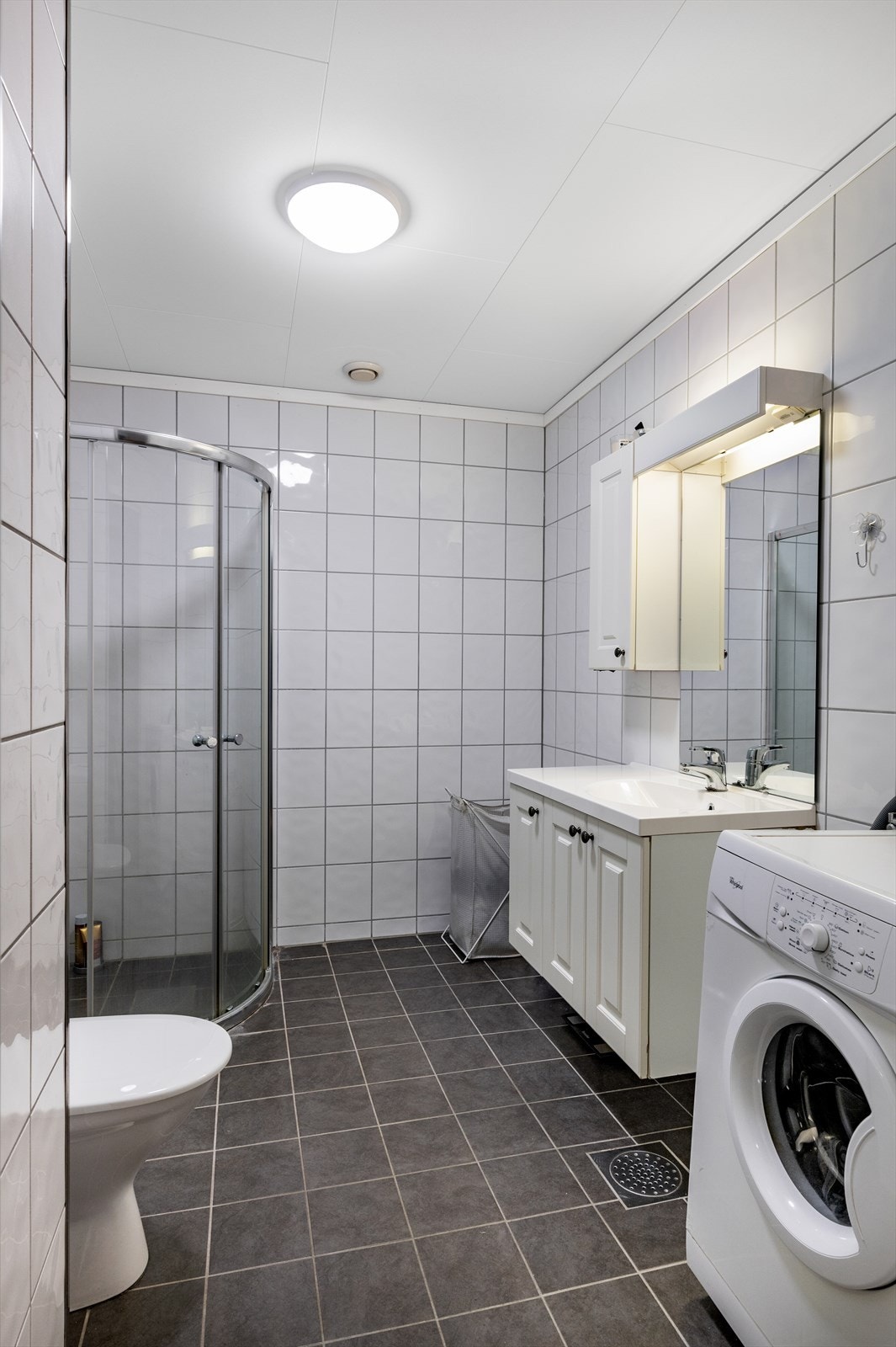 Badet har innredning med heldekkende servant, klosett og dusj med dusjvegger. Galleribilde