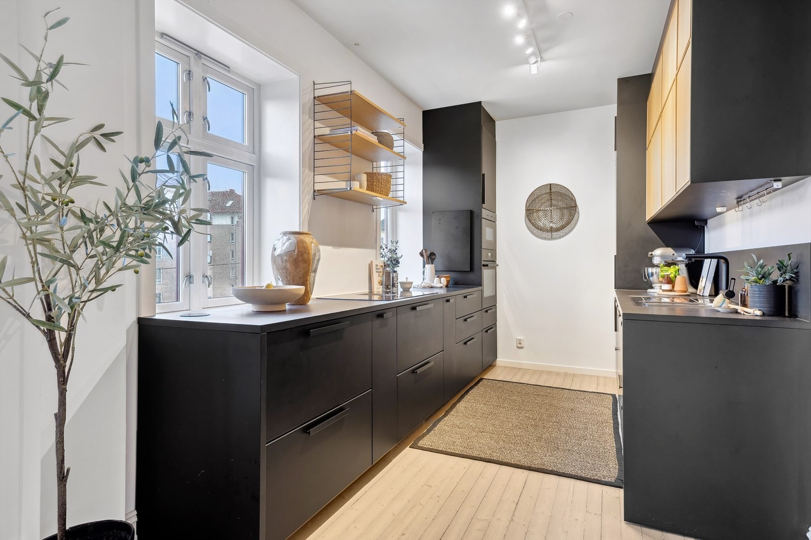 Kjøkkeninnredning glatte fronter og metallhåndtak, benkeplater i laminat, stålkum med blandebatteri Galleribilde