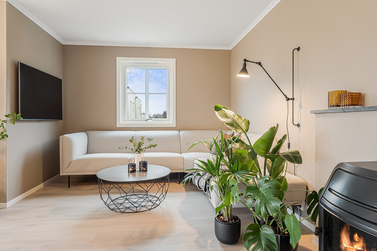 Romslig stue med plass til flere sittegrupper. Veggene er malt i en lys og lun farge. Galleribilde