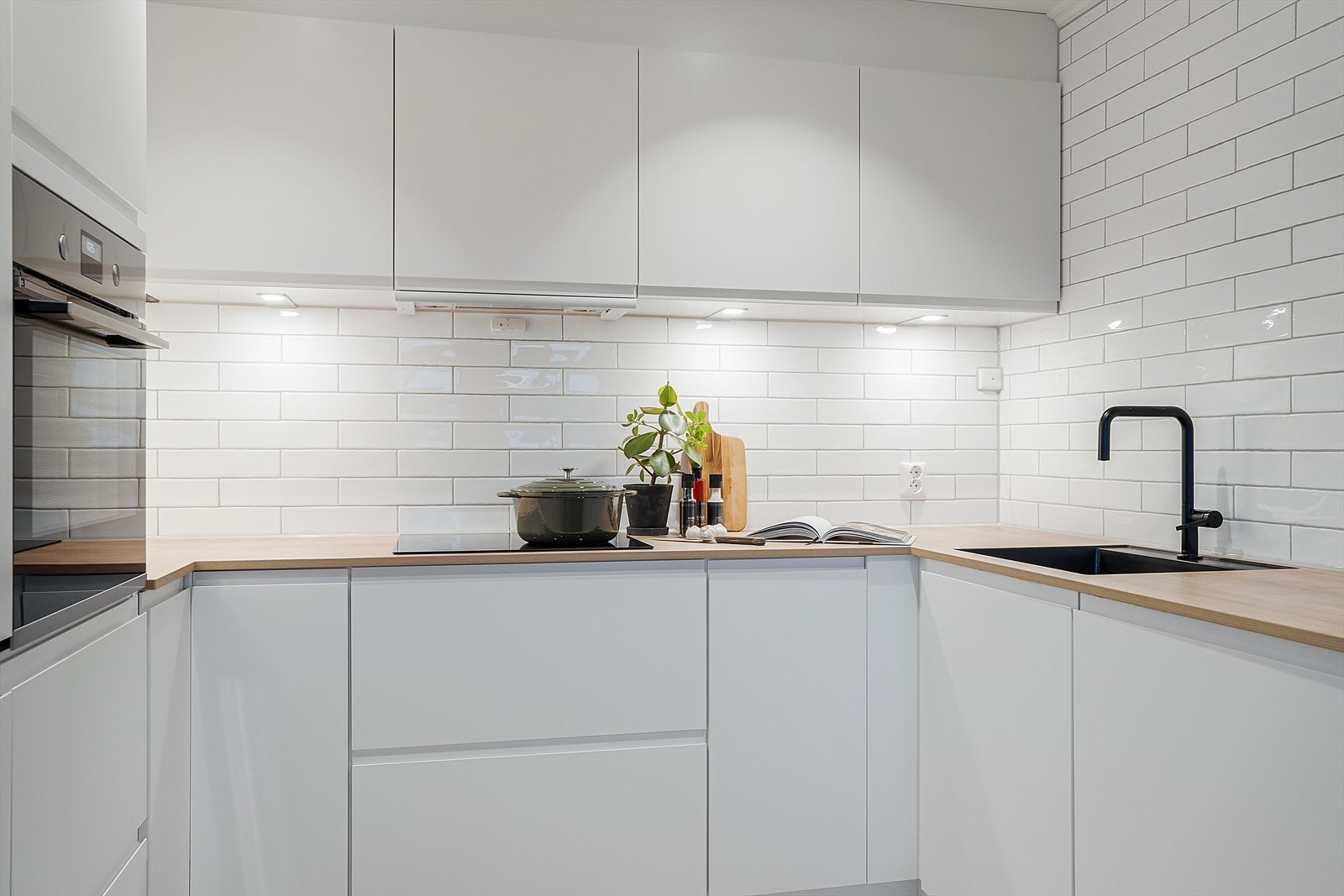 I tillegg er det spotter under overskap som gir godt med arbeidslys. Vasken er i sort utførelse og nedfelt i benkeplaten. Galleribilde