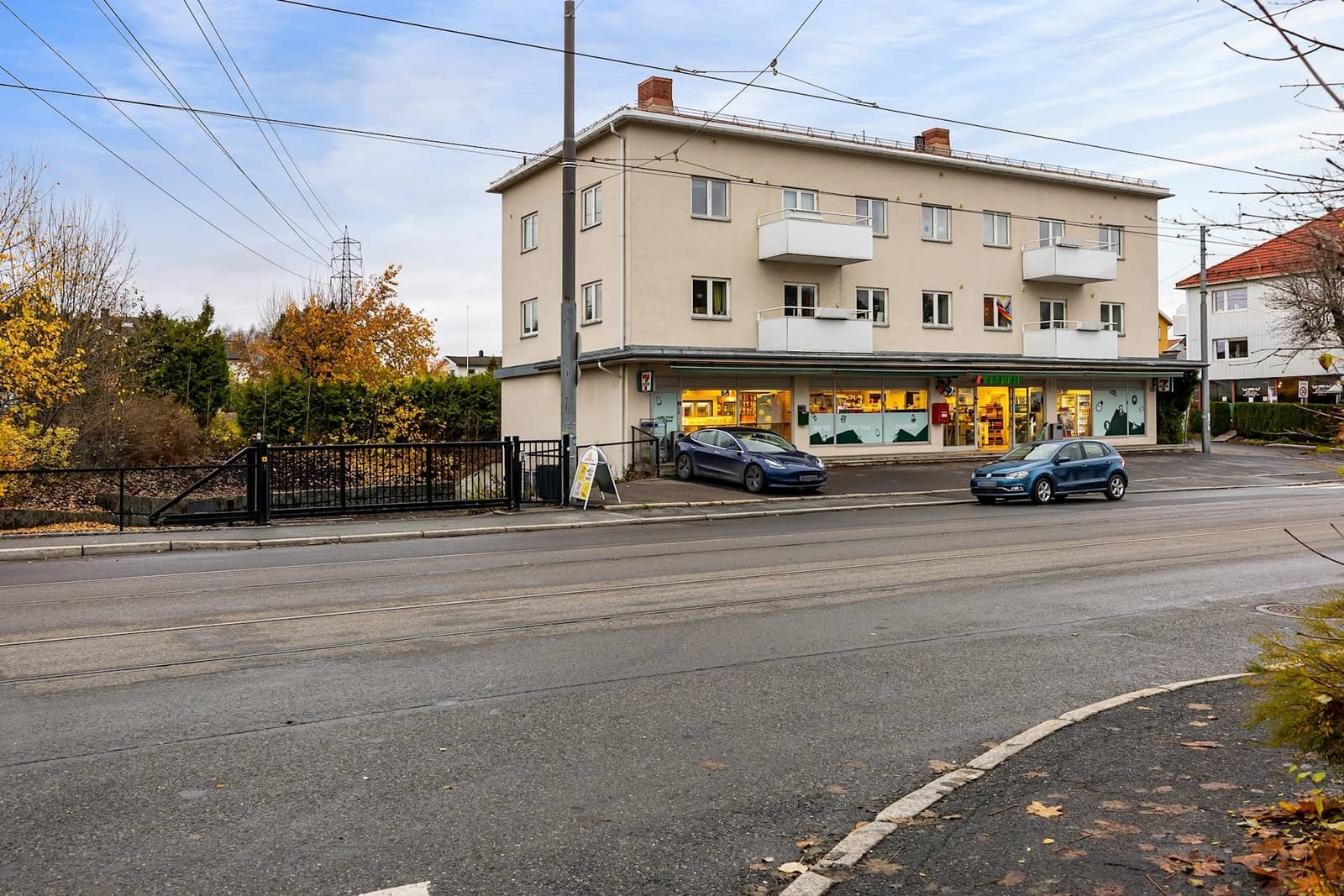 Bygget med inngjerdet parkeringsplassen til venstre. Galleribilde