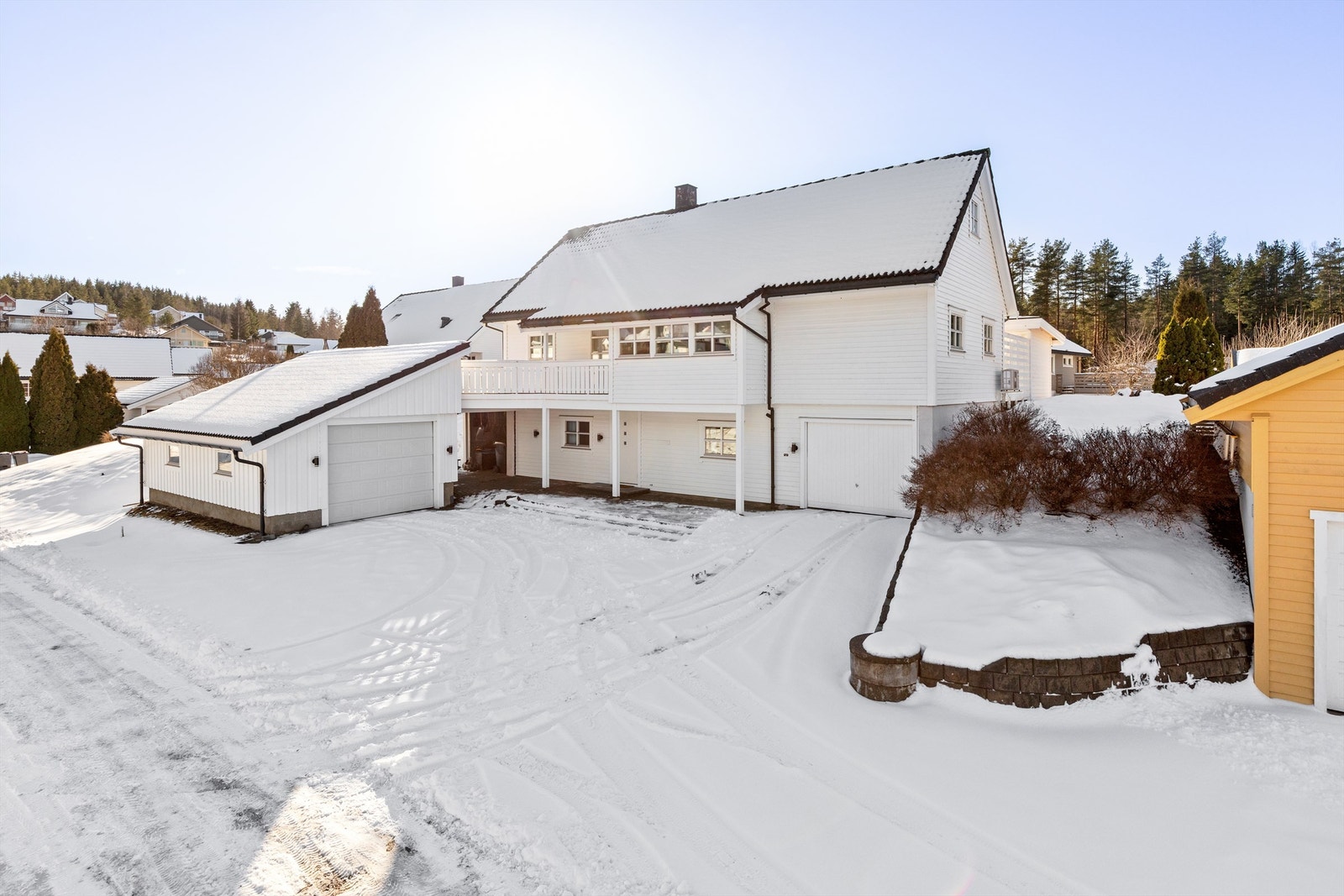 Relativt flat tomt med gode parkeringsmuligheter både på fremsiden av huset, i garasje integrert i huset og i separat garasje Galleribilde
