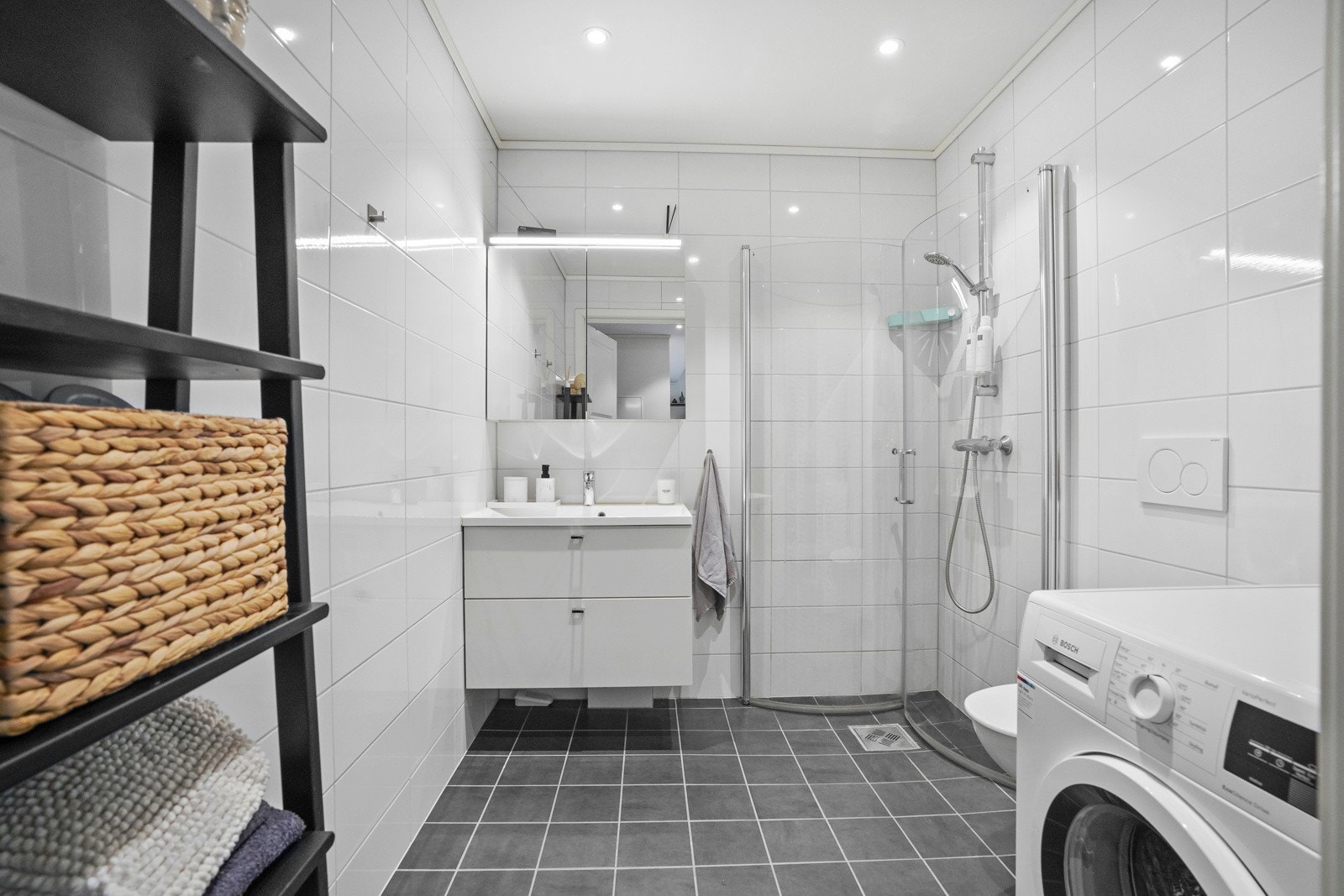 Badet har flislagte overflater og en tidløs innredning Galleribilde