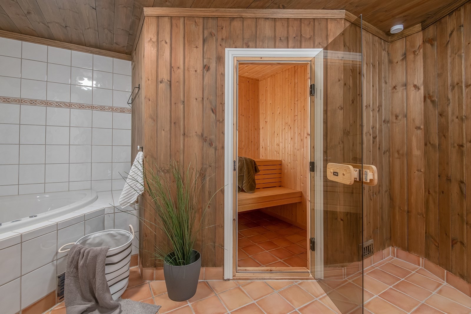 Badet har også en badstue med fliser på gulvet og panel på veggene. Galleribilde