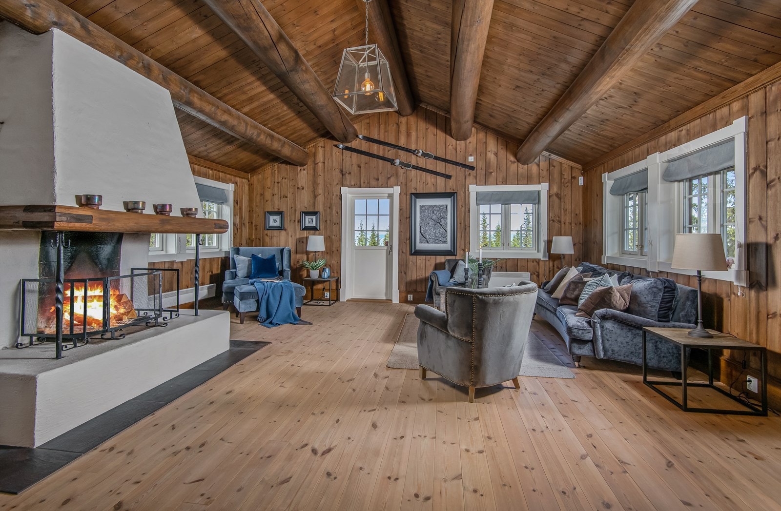 Stuen er romslig og har ekstra god takhøyde. Synlige tømmeråser gir hytta et robust og solid preg. Galleribilde