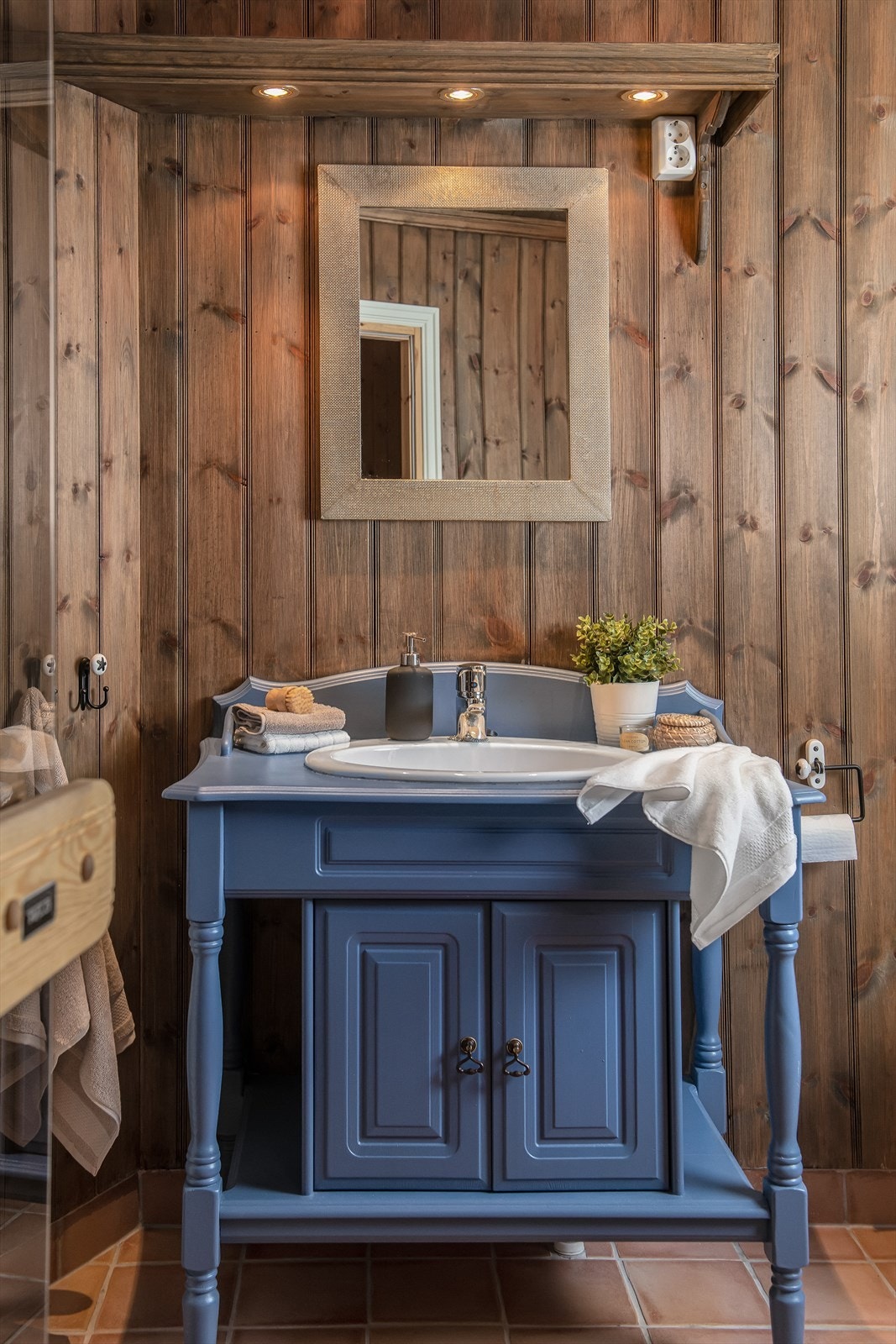 Baderomsinnredningen er i samme blåfarge som kjøkkeninnredningen. Galleribilde