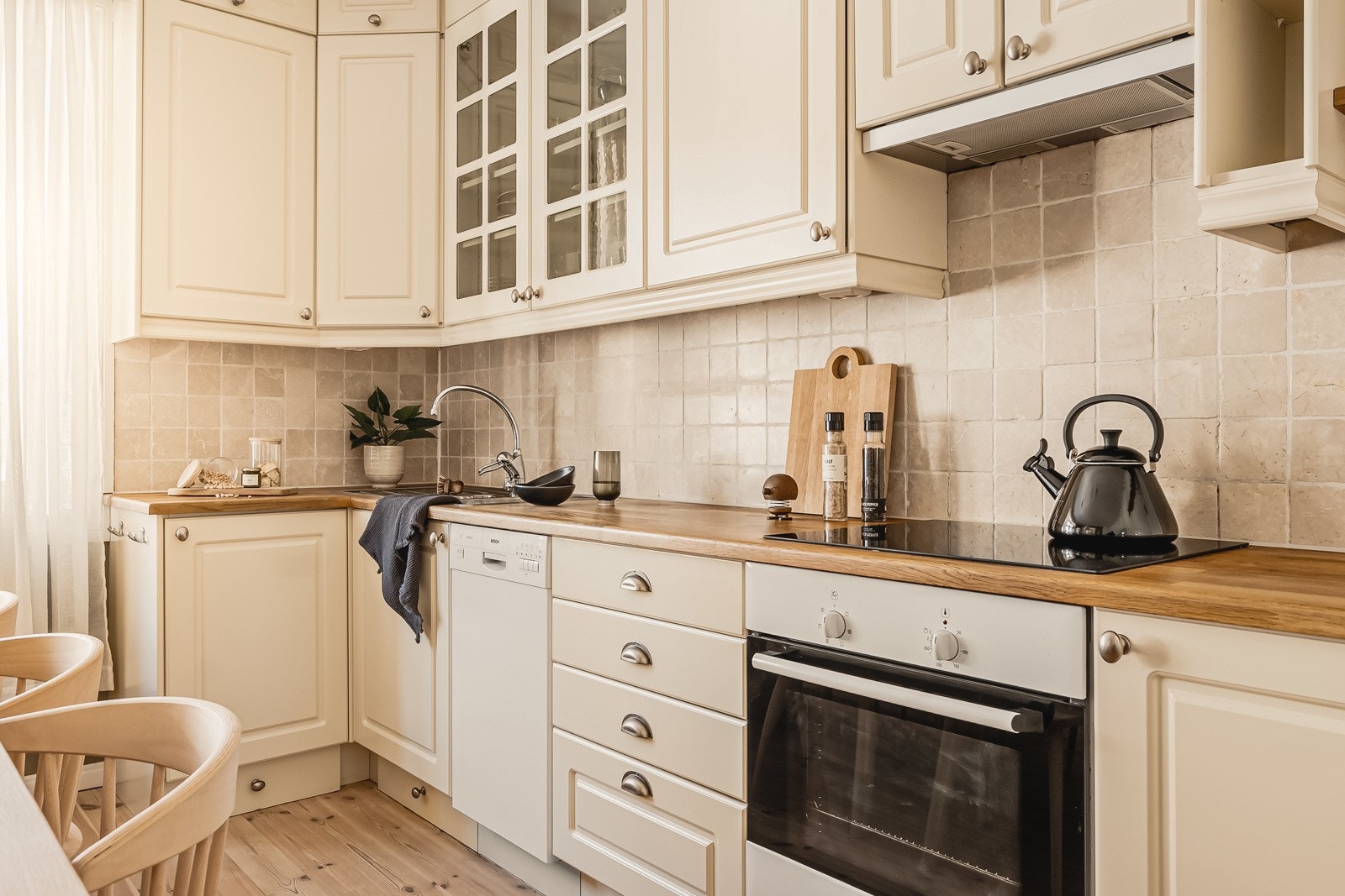 Kjøkkenet har innredning med profilerte fronter, heltre benkeplate, oppvaskkum i stål og ventilator Galleribilde