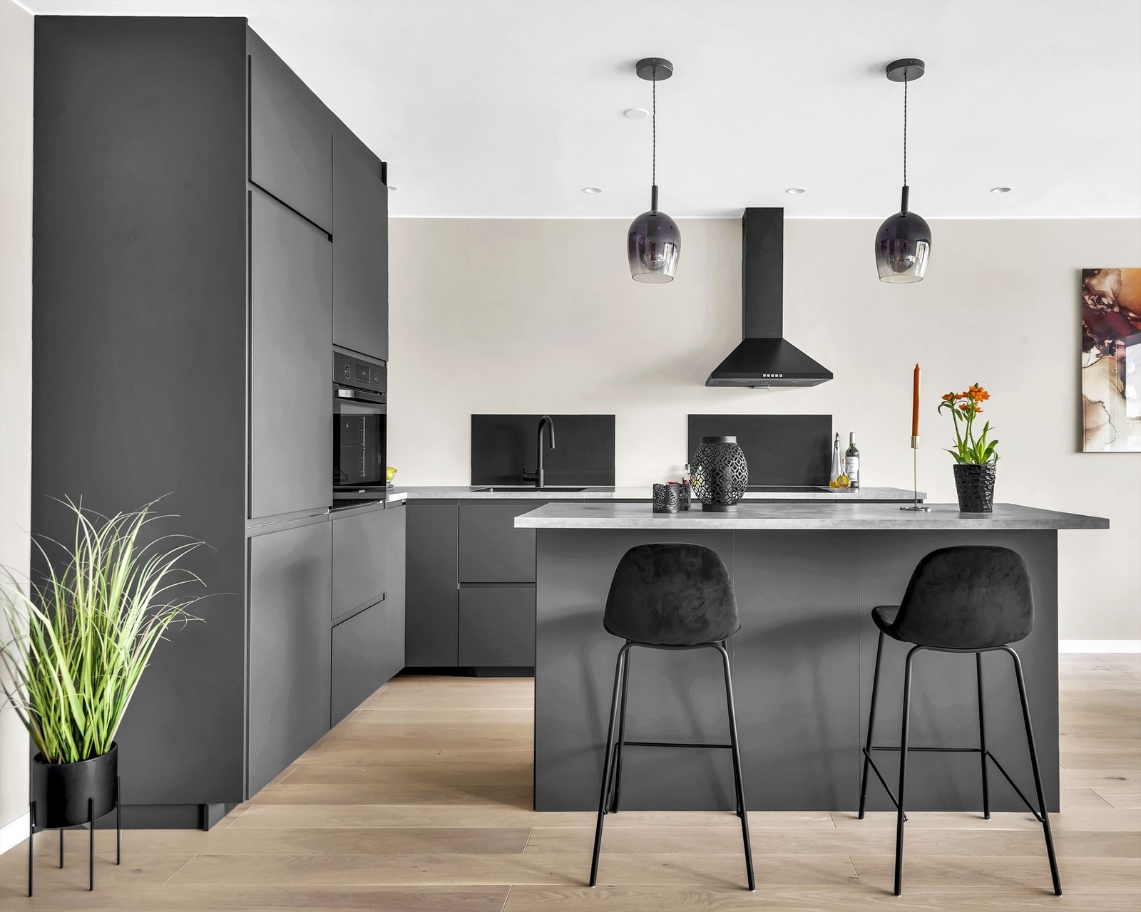 Kjøkkenet har integrerte hvitevarer som kjøleskap med frysedel, komfyr i høyskap, oppvaskmaskin under benk, nedfelt induksjonplatetopp og nedfelt vaskekum Galleribilde