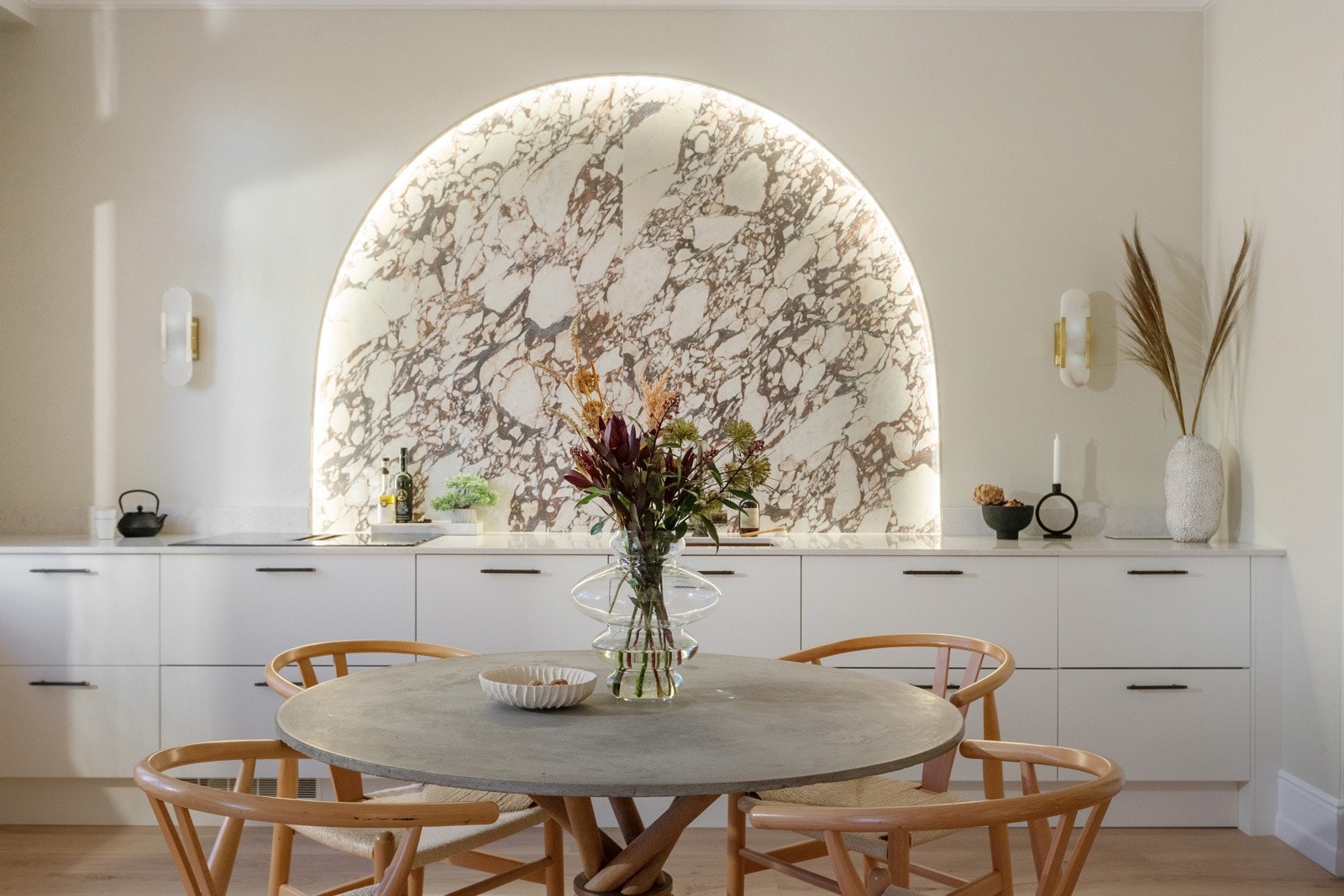 Over kjøkkenbenken er det laget en bue i marmor som er like praktisk som backsplash som den er dekorativ. Det er god plass til stort spisebord ved siden av kjøkkenet Galleribilde