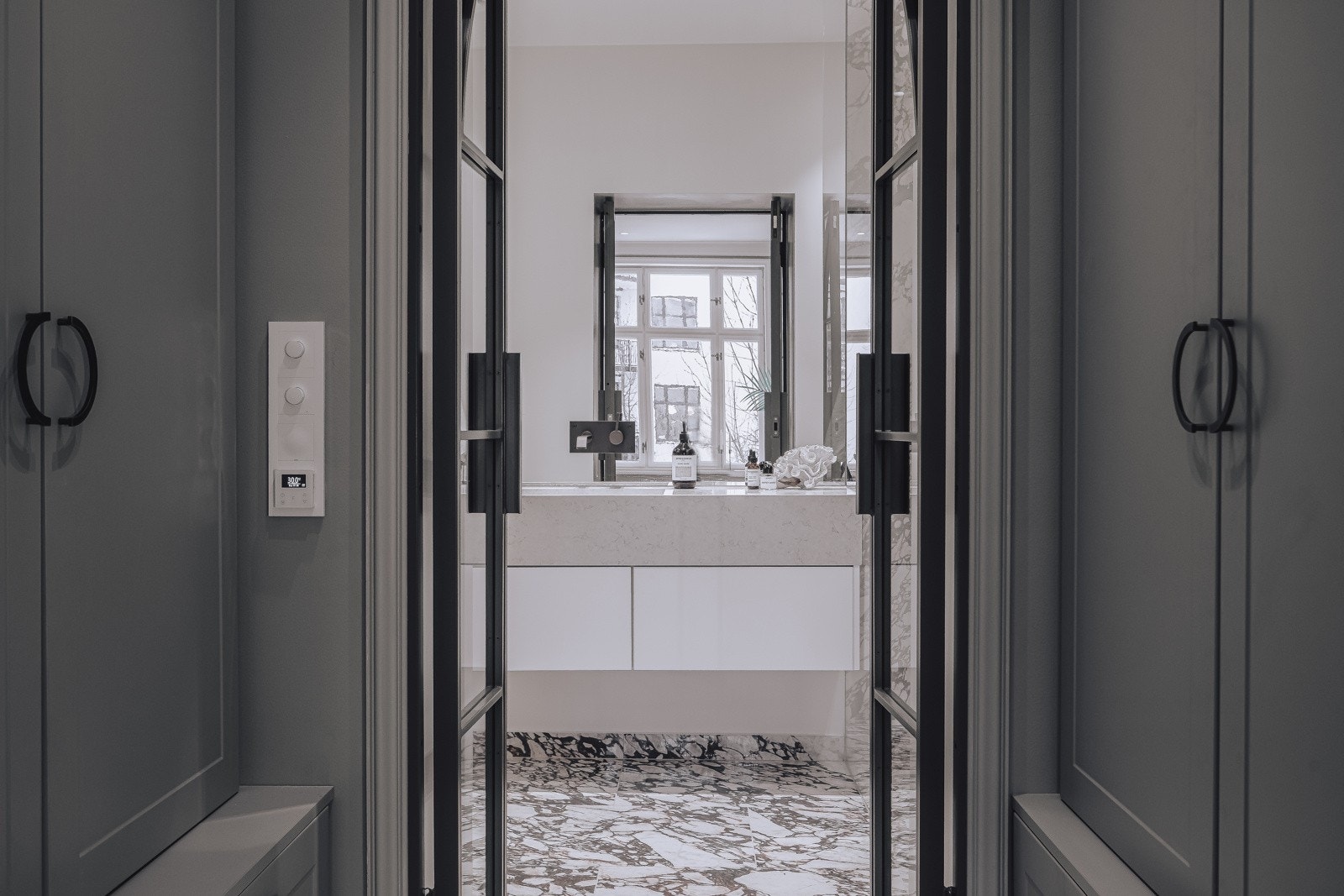 Dørene inn til baderommet er i glass, med bronse sprosser og rammer. Denne er spesialtilpasset for leiligheten Galleribilde