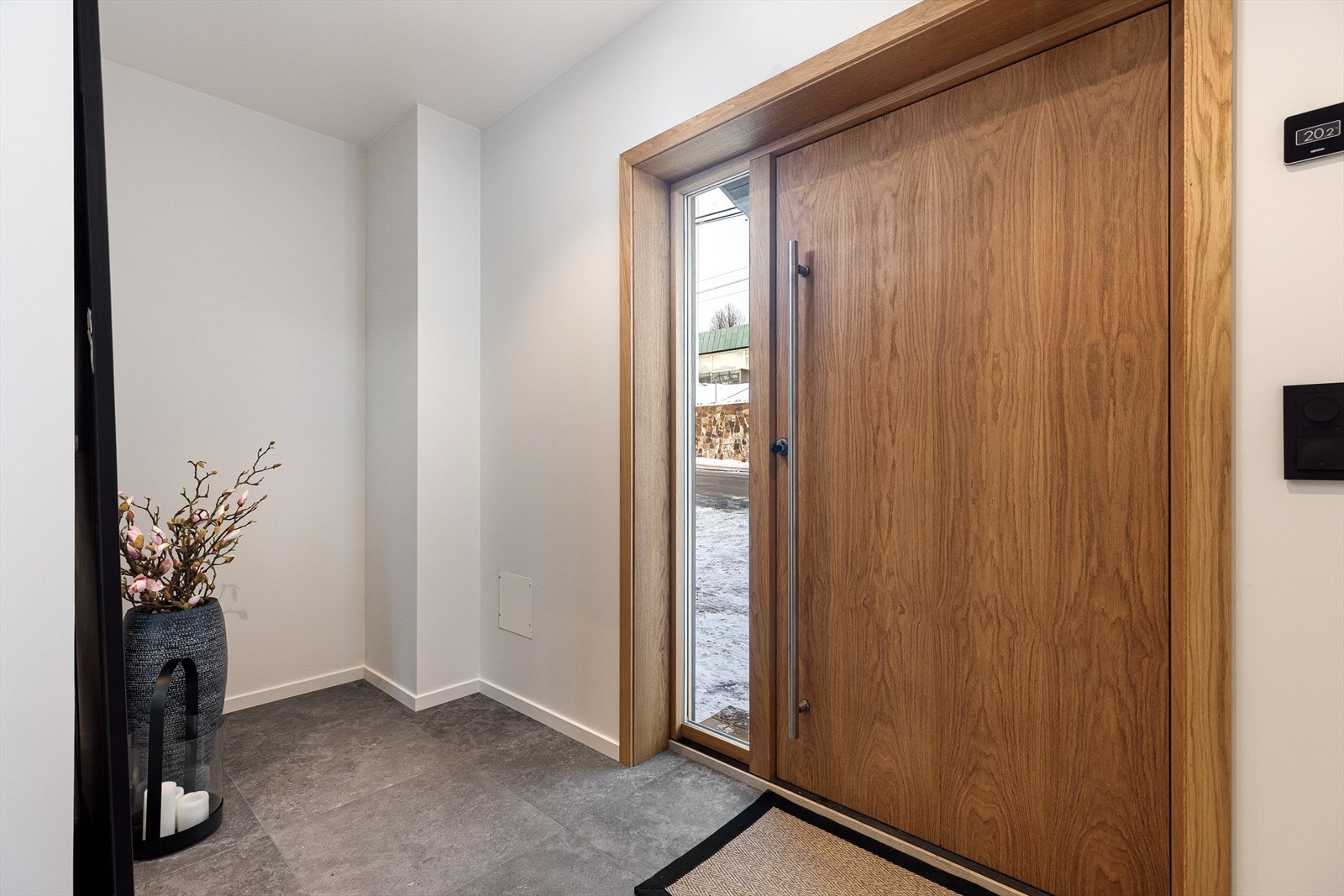 Flislagt entré med garderobenisje. Påkostet heltre ytterdør i eik fra Ege Dør. Galleribilde