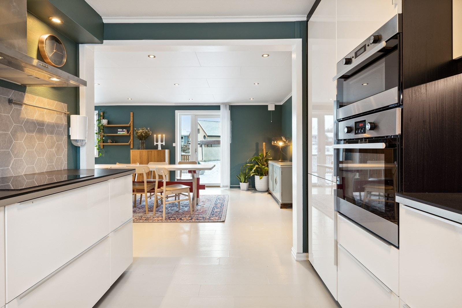 Moderne kjøkken fra 2015 utformet i hesteskoform med takhøy innredning og glatte høyglans fronter. Galleribilde