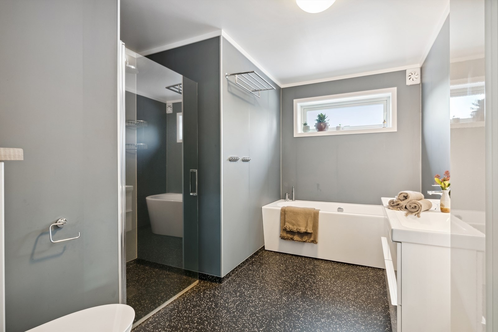 I rommet finnes det tidløs baderomsinnredning m/heldekkende dobbel servant, skuffer, høyskap og rundt speil m/lys, dusjnisje m/glassdør og dusjgarnityr, badekar og vegghengt toalett m/skjult sisterne. Galleribilde