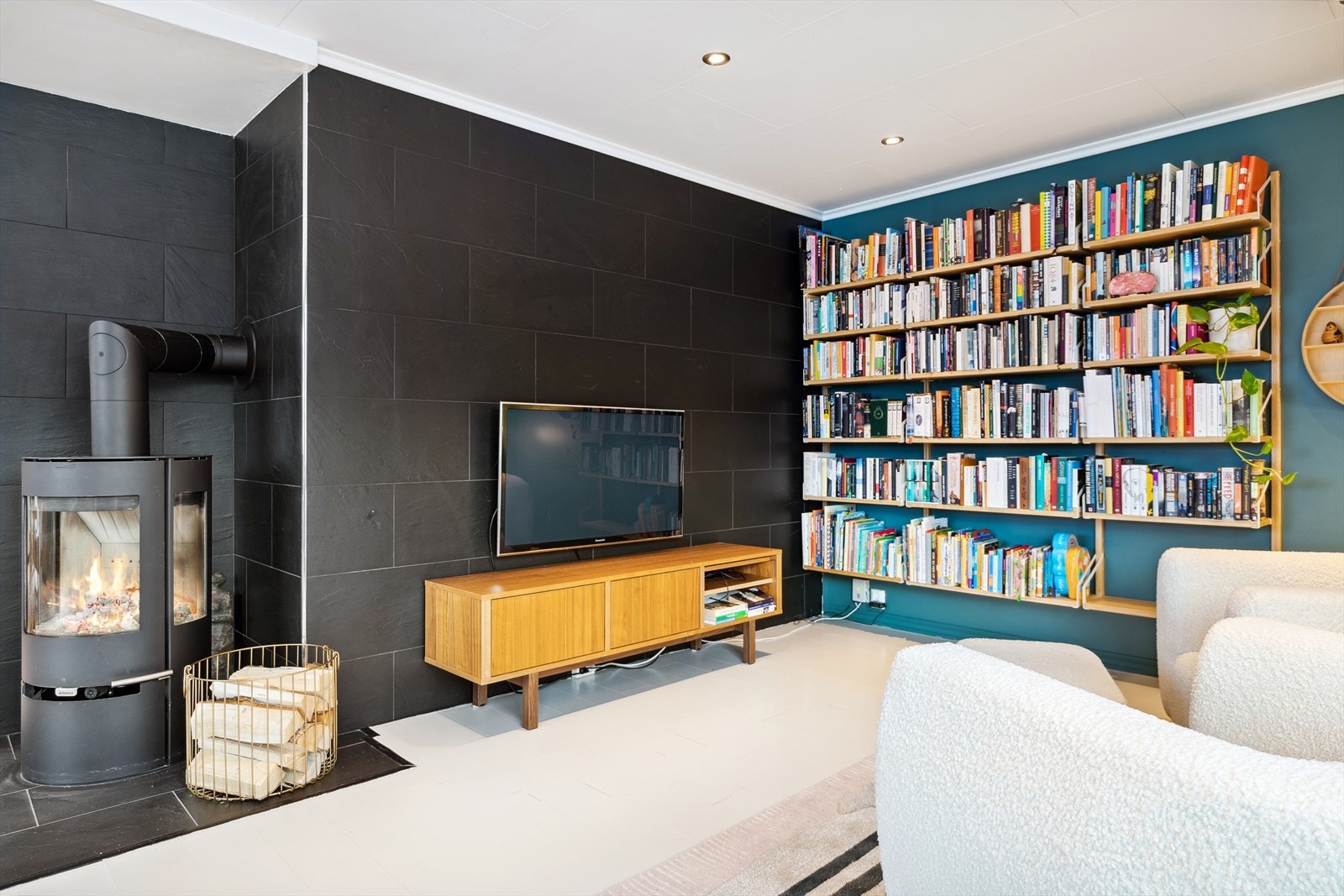 Flislagt branntavle i sort design skaper en lekker kontrast til resten av rommet. Galleribilde