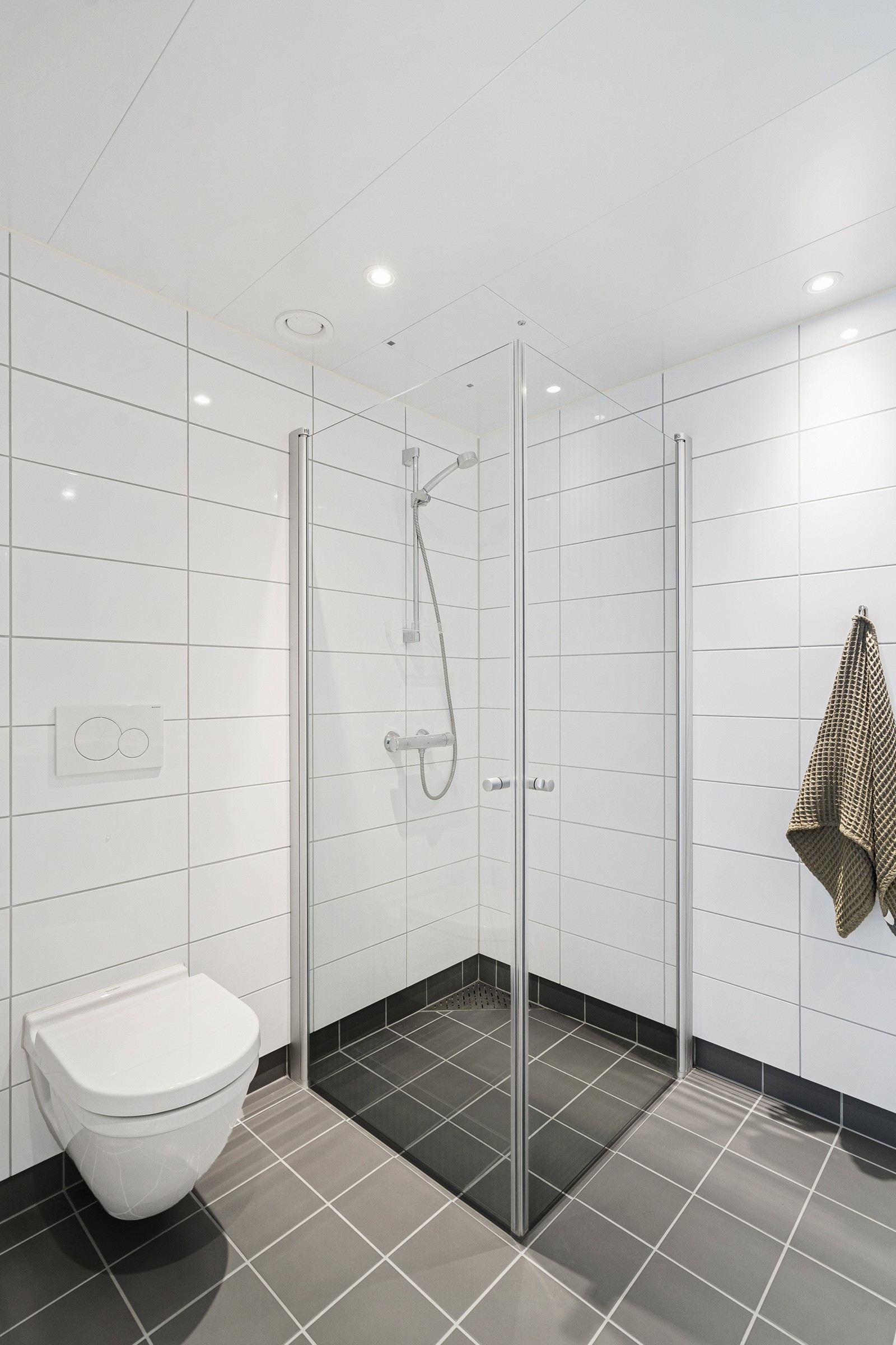 På badet er det vegghengt toalett og dusjhjørne.