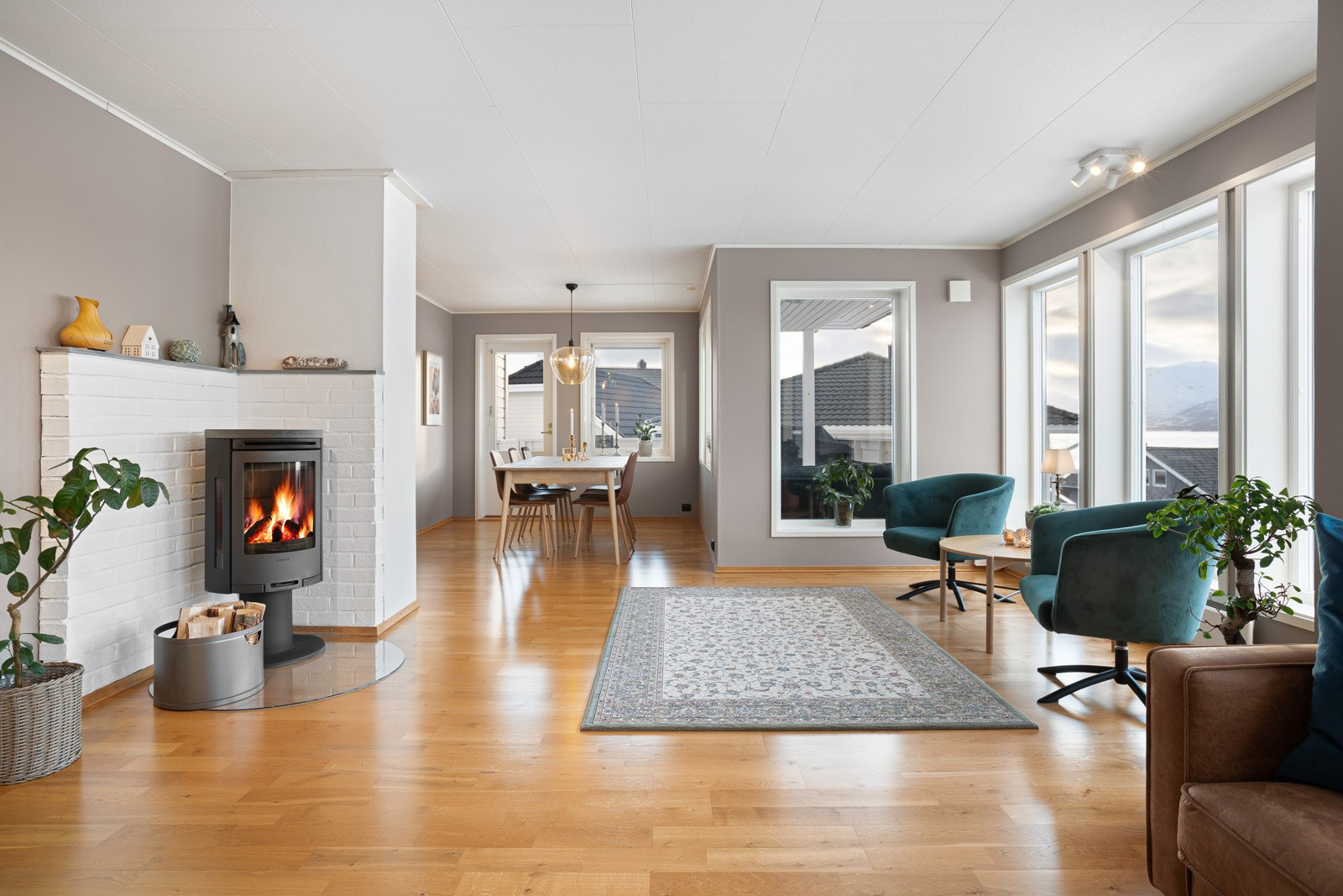 Stor stue med naturlige soner for møblering som sittegrupper og spisebord.