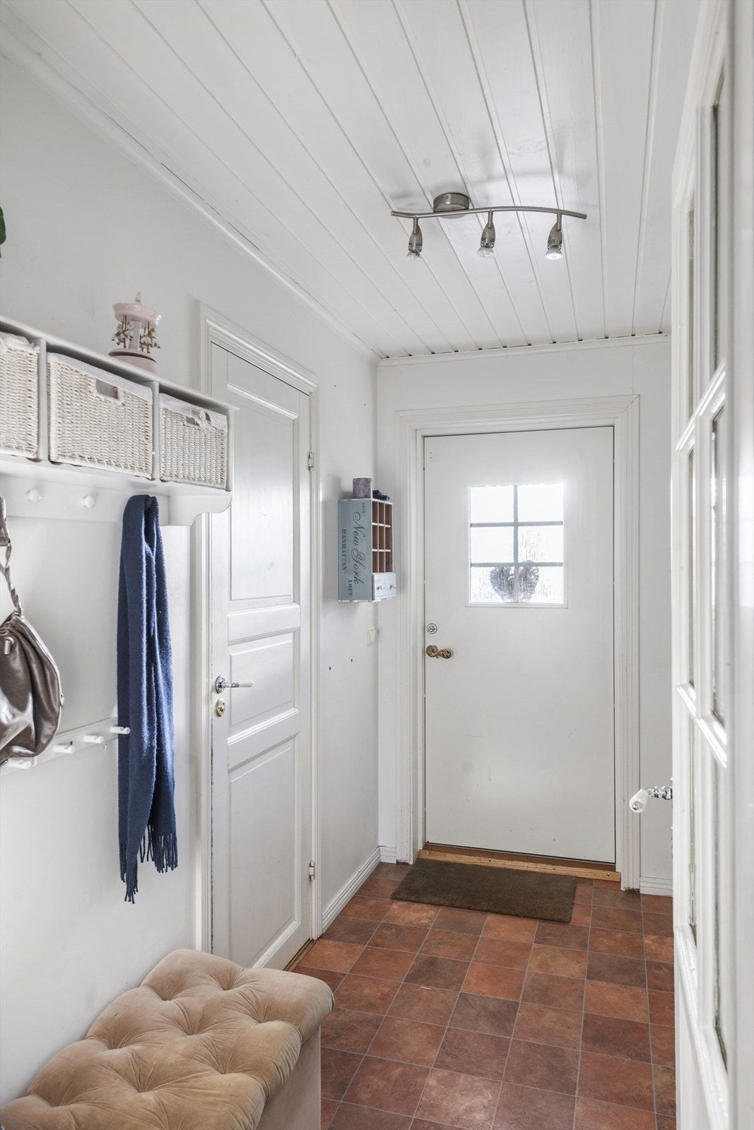 Lys entré med plass for å henge fra seg yttertøy og sko. Dør inn til bad. Galleribilde