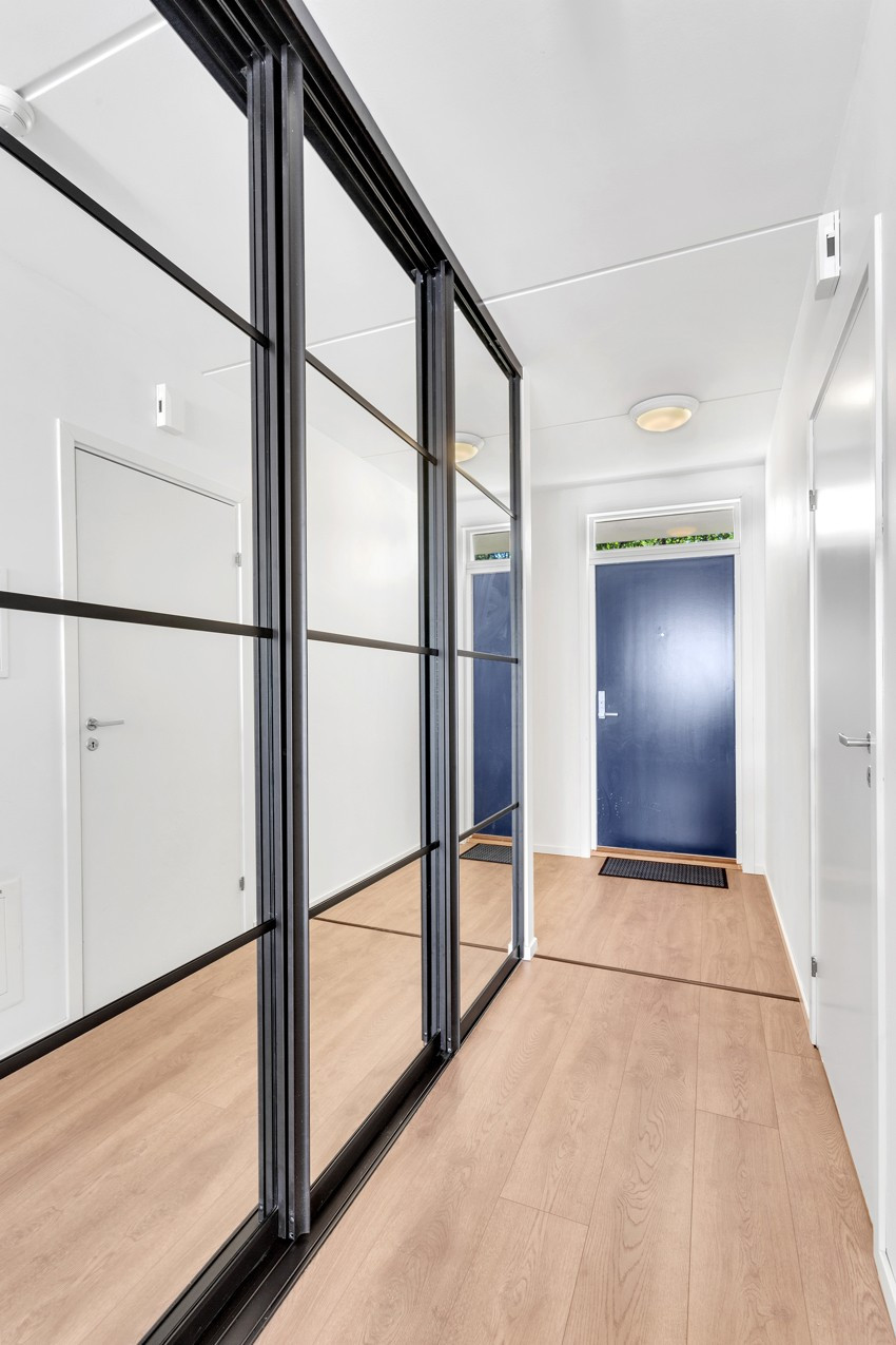 Romslig entrè med praktisk skyvedørsgarderobe og god plass til oppbevaring av yttertøyet.