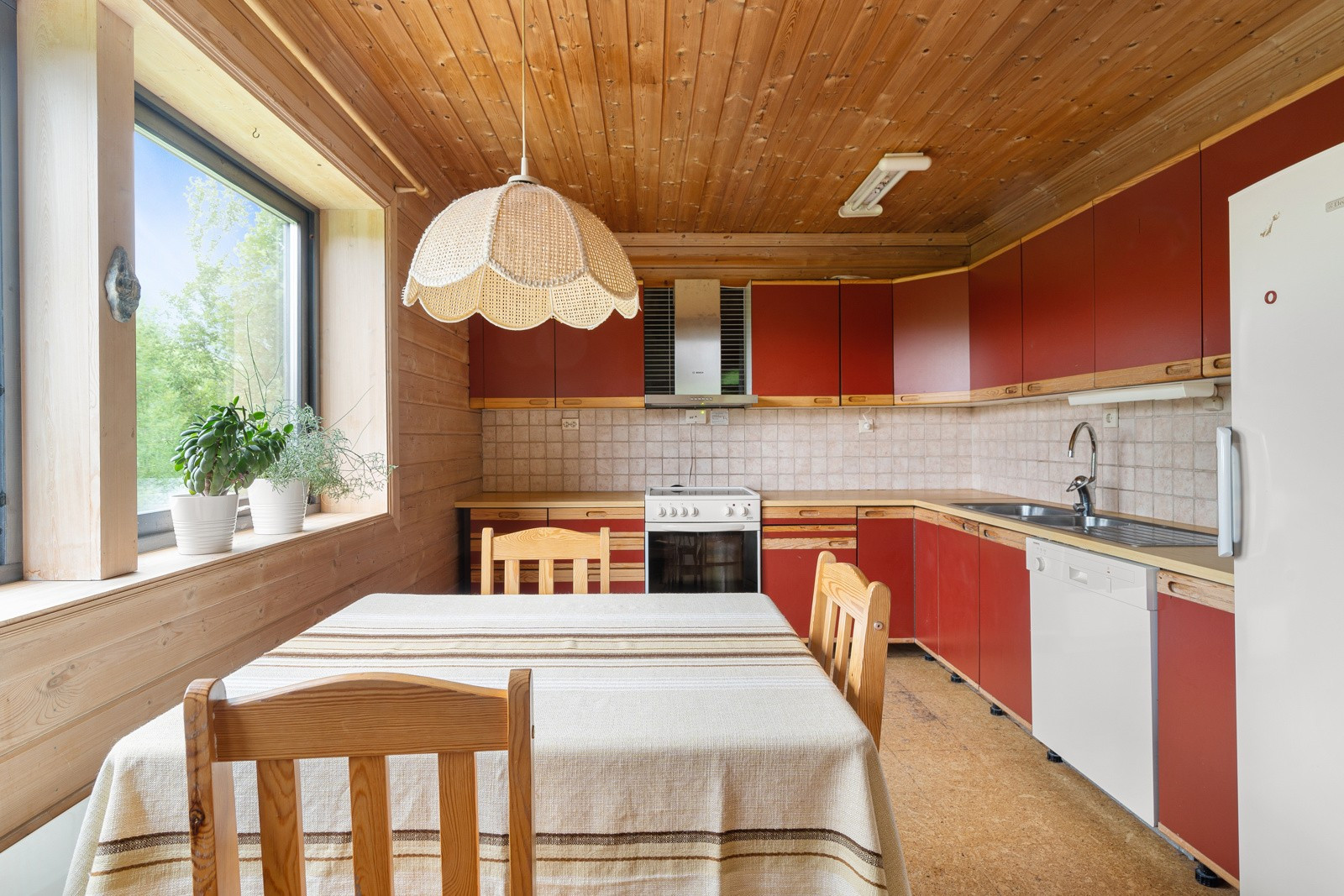 Boligens kjøkken har en innredning med glatte fronter og benkeplate av laminat.