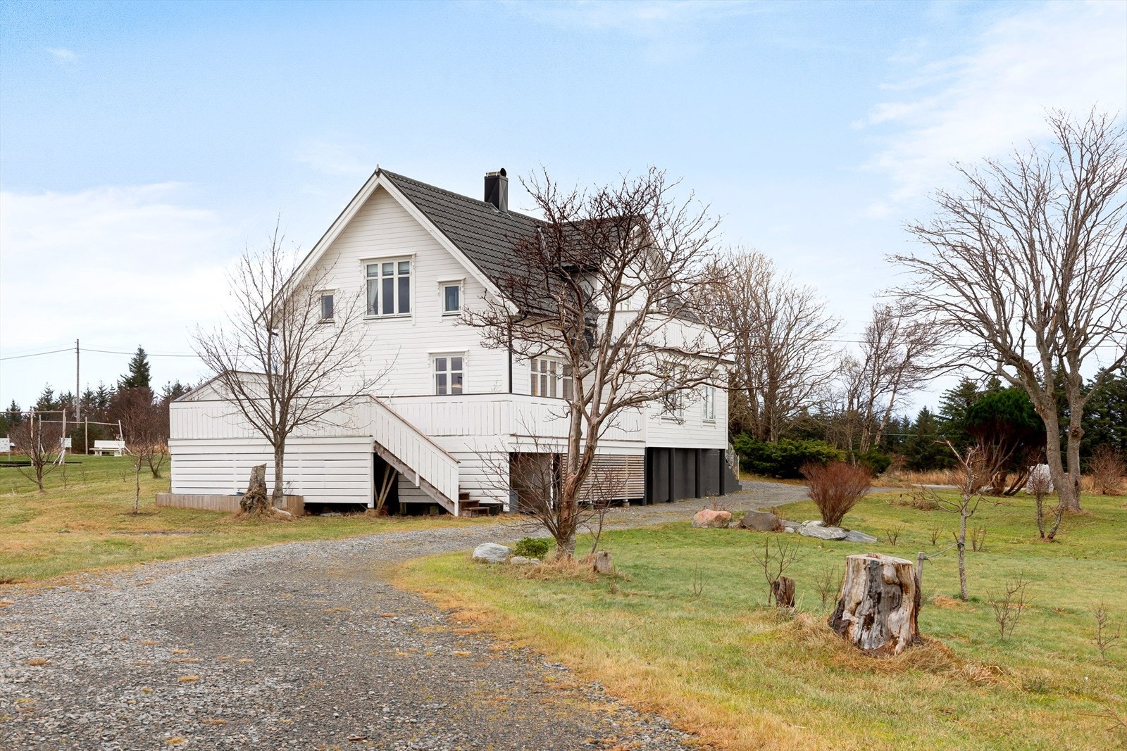 Tomten er opparbeidet med gruset adkomstveg, plen og beplantning etc. Galleribilde