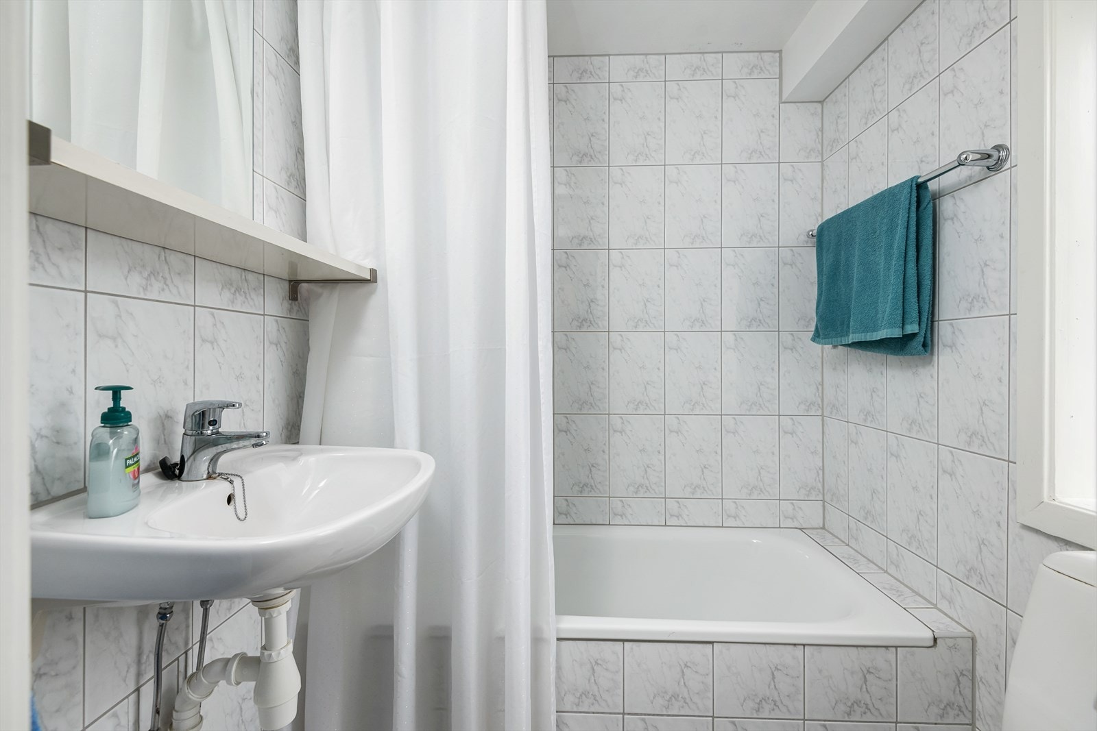 Bad har flis på gulv og vegger. Varmekabler i gulv. Innkasset badekar med dusjarmatur på vegg. Galleribilde