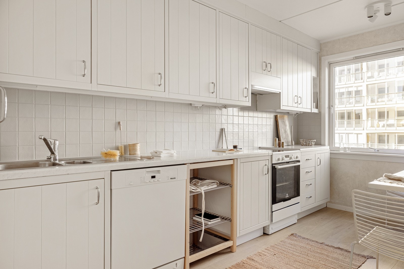 Kjøkkenet har en innredning med hvite, profilterte fronter. Galleribilde