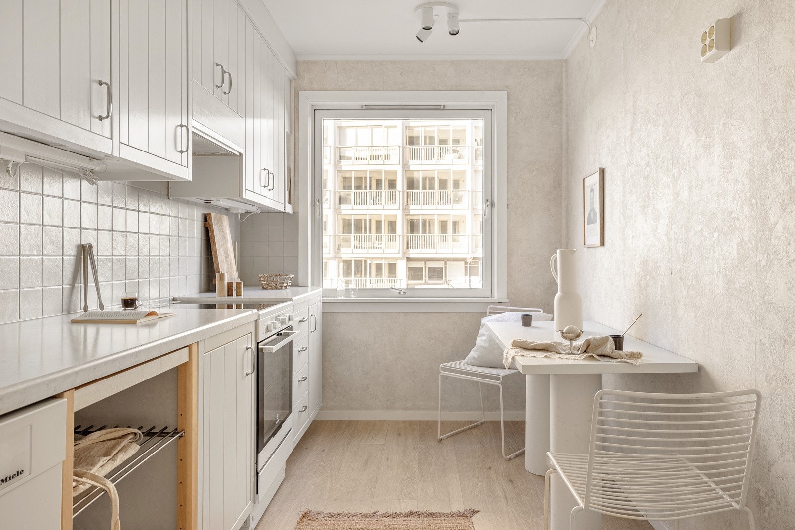 Det er fliselagt mellom over- og underskap, og benkeplaten er av laminat. Galleribilde