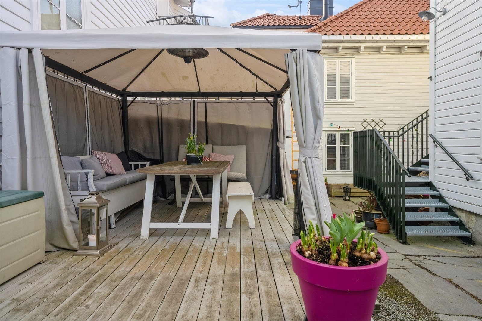 Bakgården er belagt med skiferheller, har en treplatting med plass for paviljongtelt og oppleves som en privat idyll om sommeren. Galleribilde