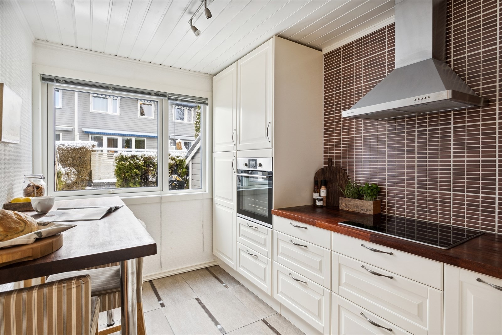 Et flott kjøkken med profilert innredning, benkeplate i heltre og fliser på vegg. Galleribilde