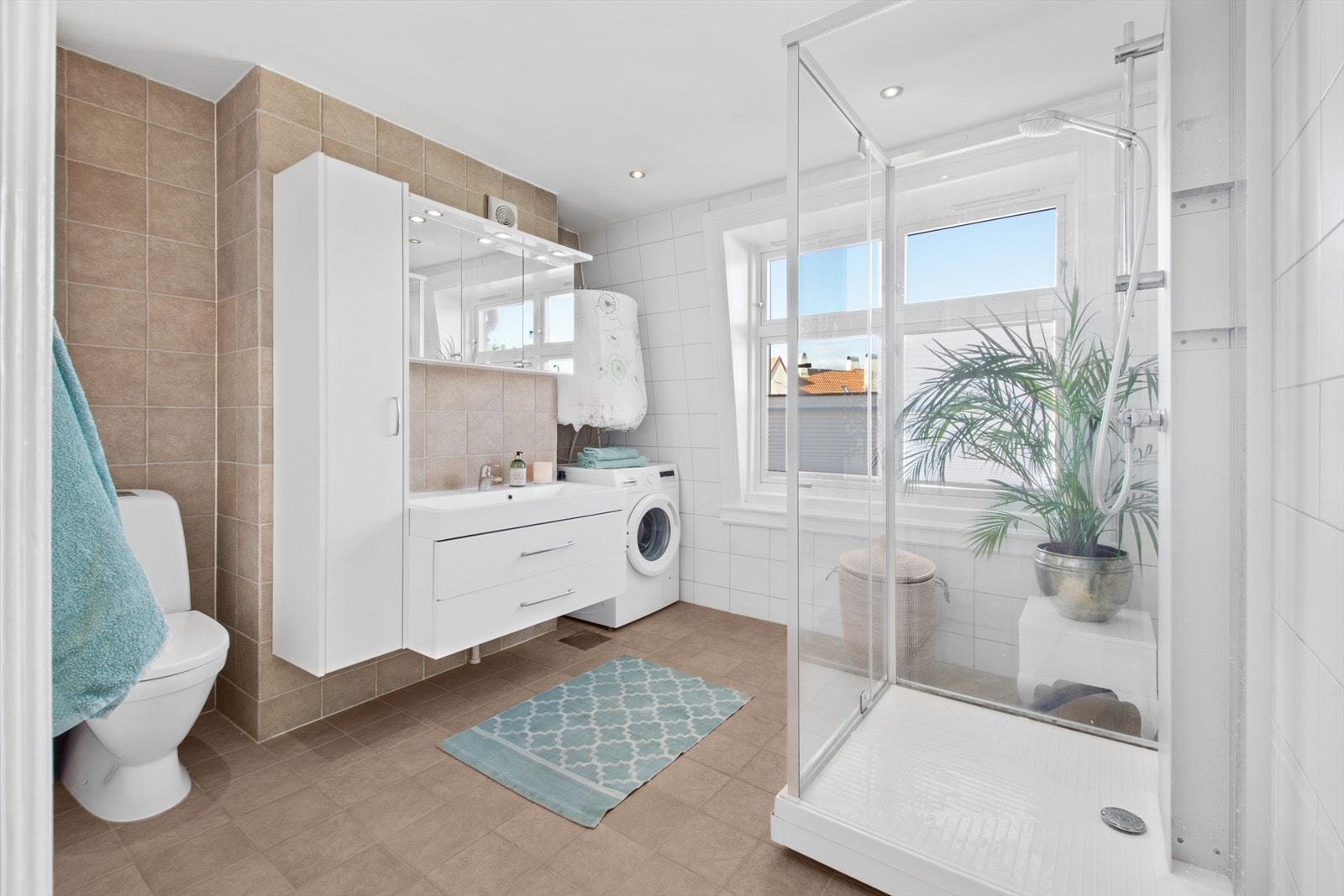 Stort, flislagt baderom med varme i gulvet og downlights i himling. Galleribilde