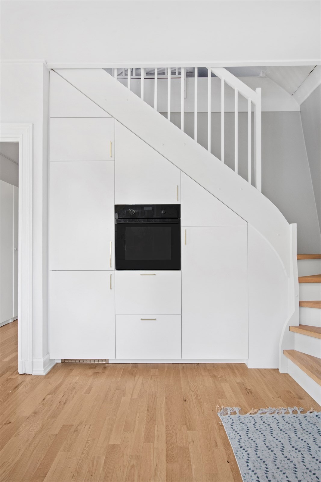 Det er integrert stekeovn, oppvaskmaskin, platetopp og kjøl/fryseskap. Tilpasset skap under trappen. Galleribilde