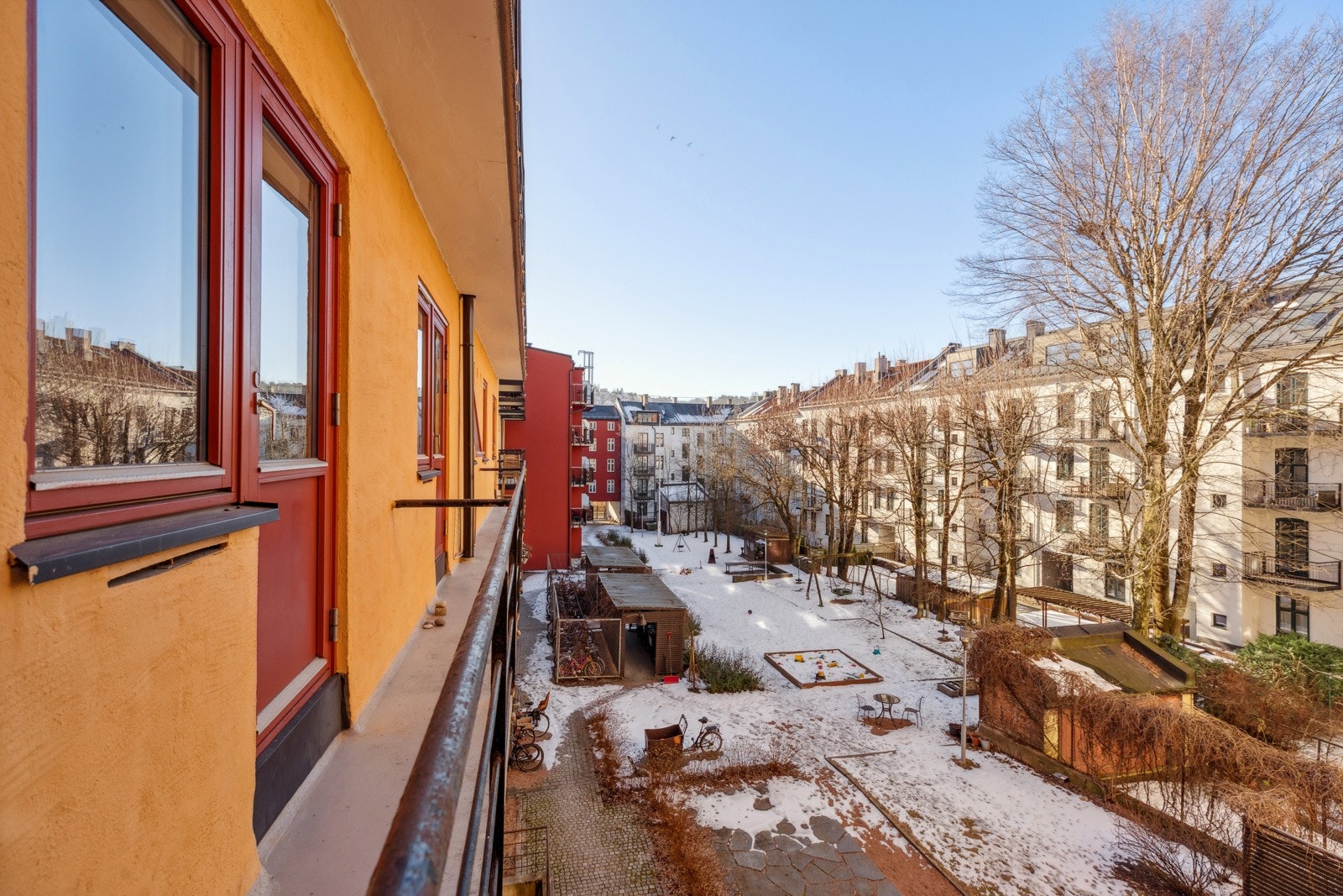 Brannbalkong ut mot felles pent opparbeidet gårdsrom med benker og bord Galleribilde