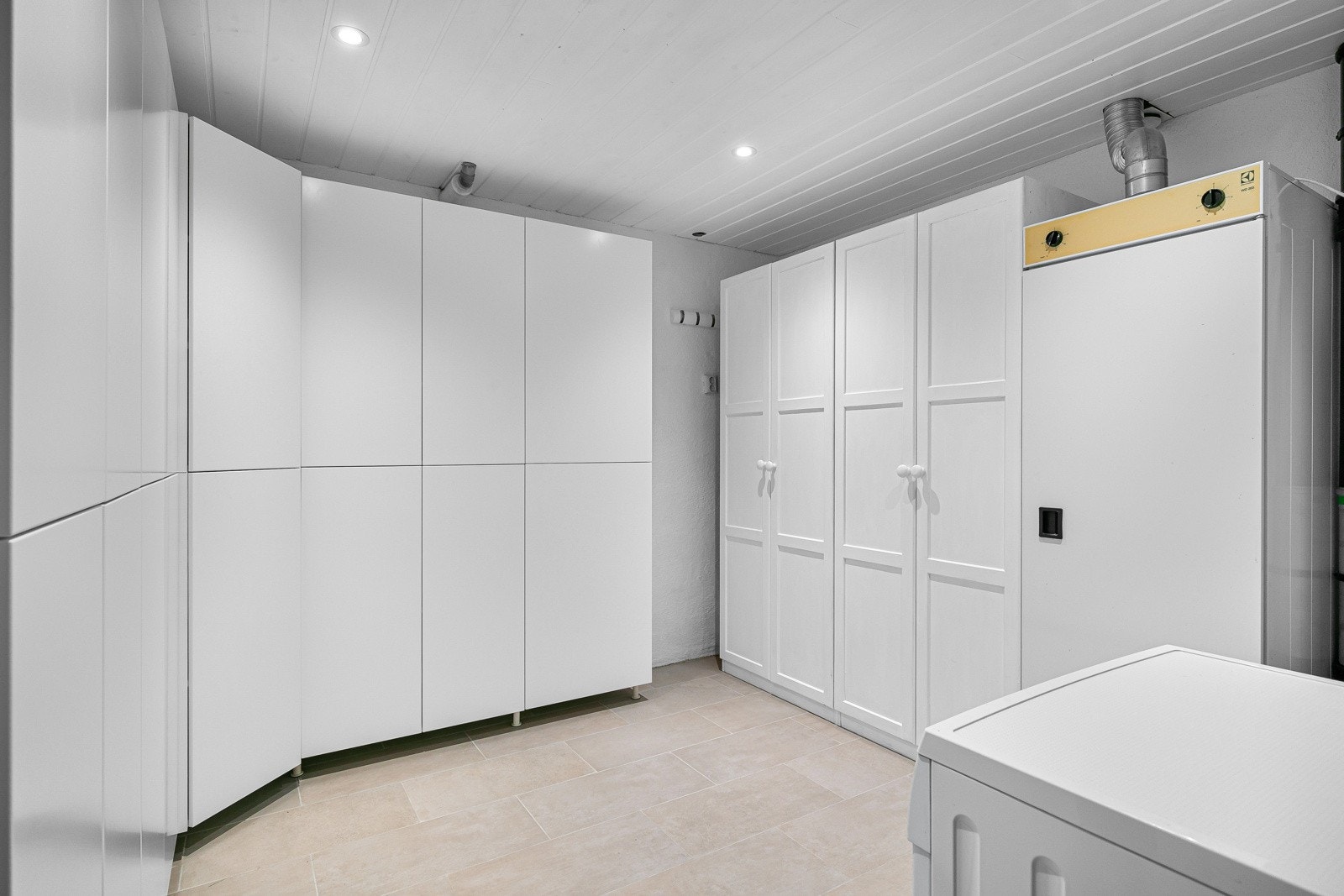 I underetasjen ligger det et stort vaskerom, innredet med flere garderobeskap. Det er også opplegg for vaskemaskin Galleribilde