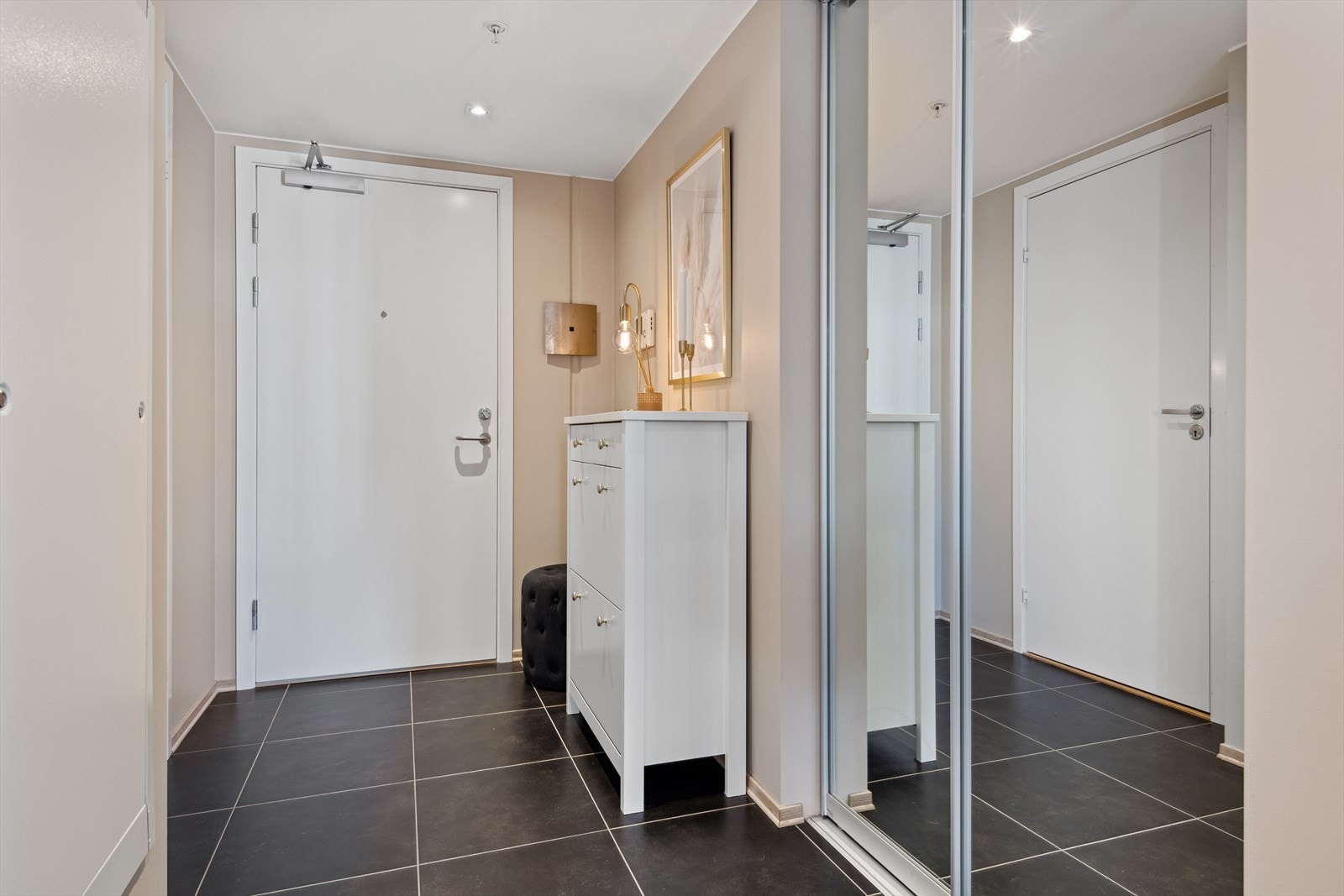 Romslig entré med plass for oppbevaring av yttertøy og sko i en pen og praktisk, integrert skyvedørsgarderobe. Galleribilde