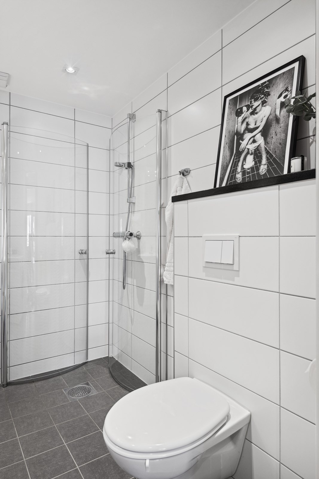 Veggmonterte dusjvegger, dusj direkte på gulv med termostat batteri, veggmontert klosett, servant med skapinnredning, speil med belysning og opplegg for vaskemaskin. Galleribilde