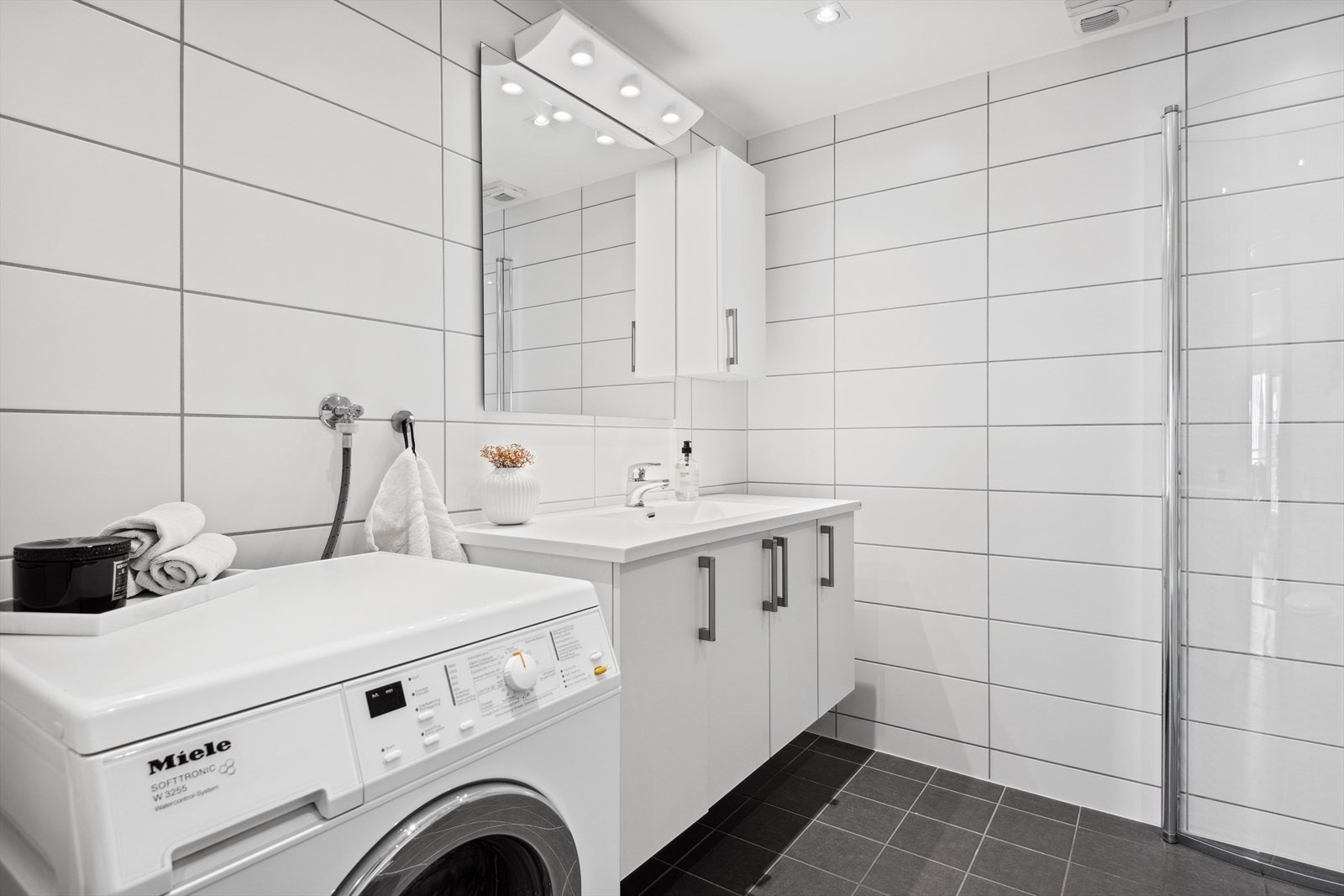 Stort og delikat baderom med moderne flis- og fargevalg. Gulv- og veggflatene består av fliser. Takflatene består av malte takflater. Galleribilde