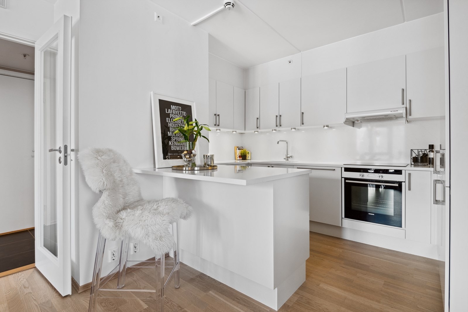 Plater i kompositt av nyere dato over benkeskap. Belysning under overskap. Galleribilde