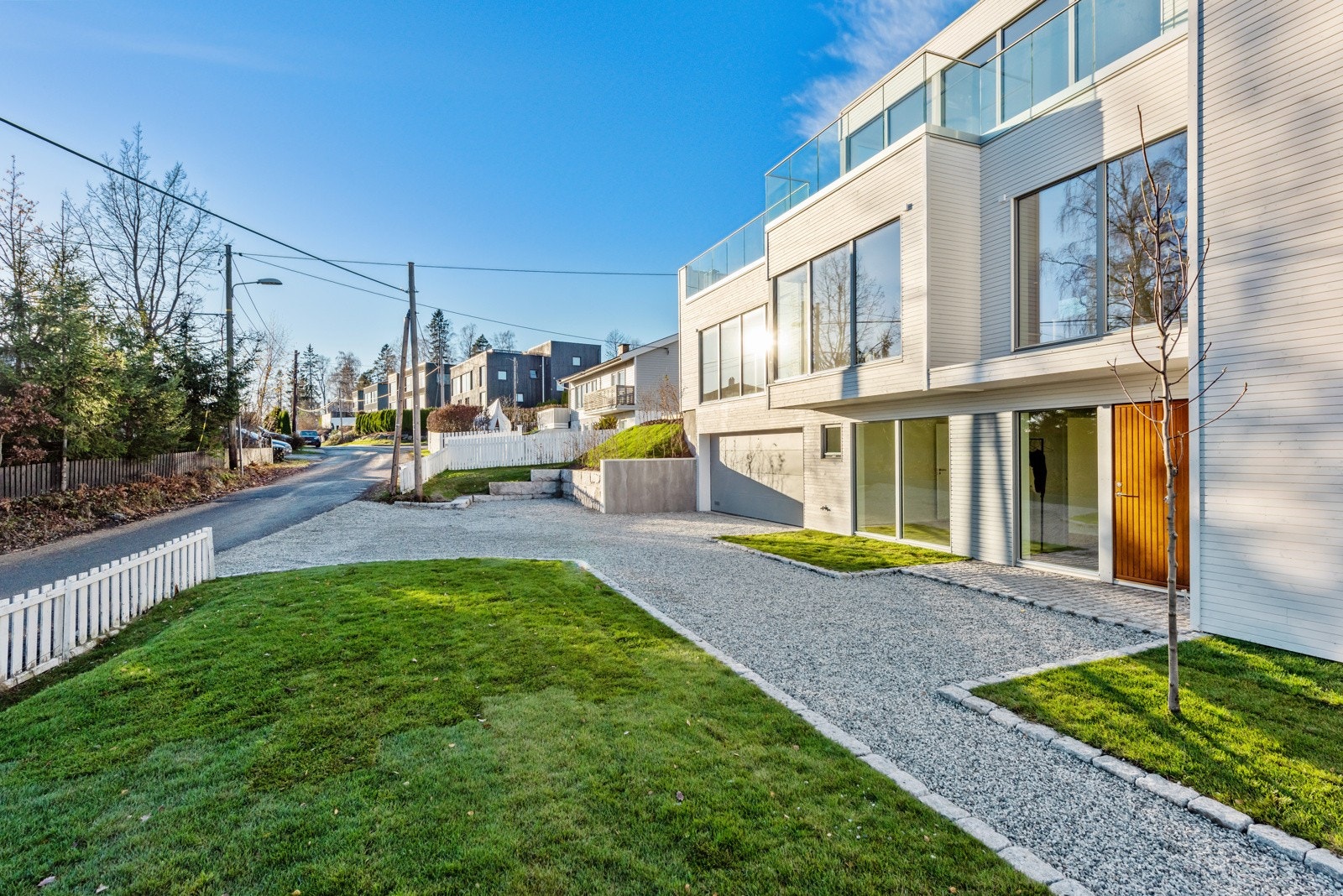 Pent opparbeidet eiendom med gressplen, beplantning og gangsoner Galleribilde