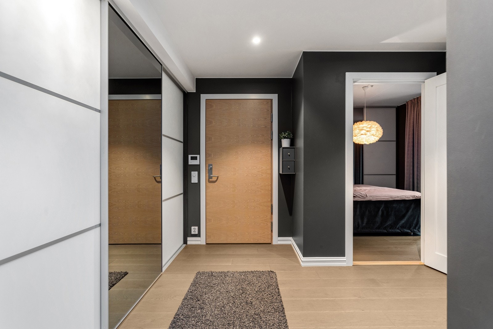 Montert porttelefon med video på vegg og sikringsskap med automatsikringer på vegg inni garderoben. Galleribilde